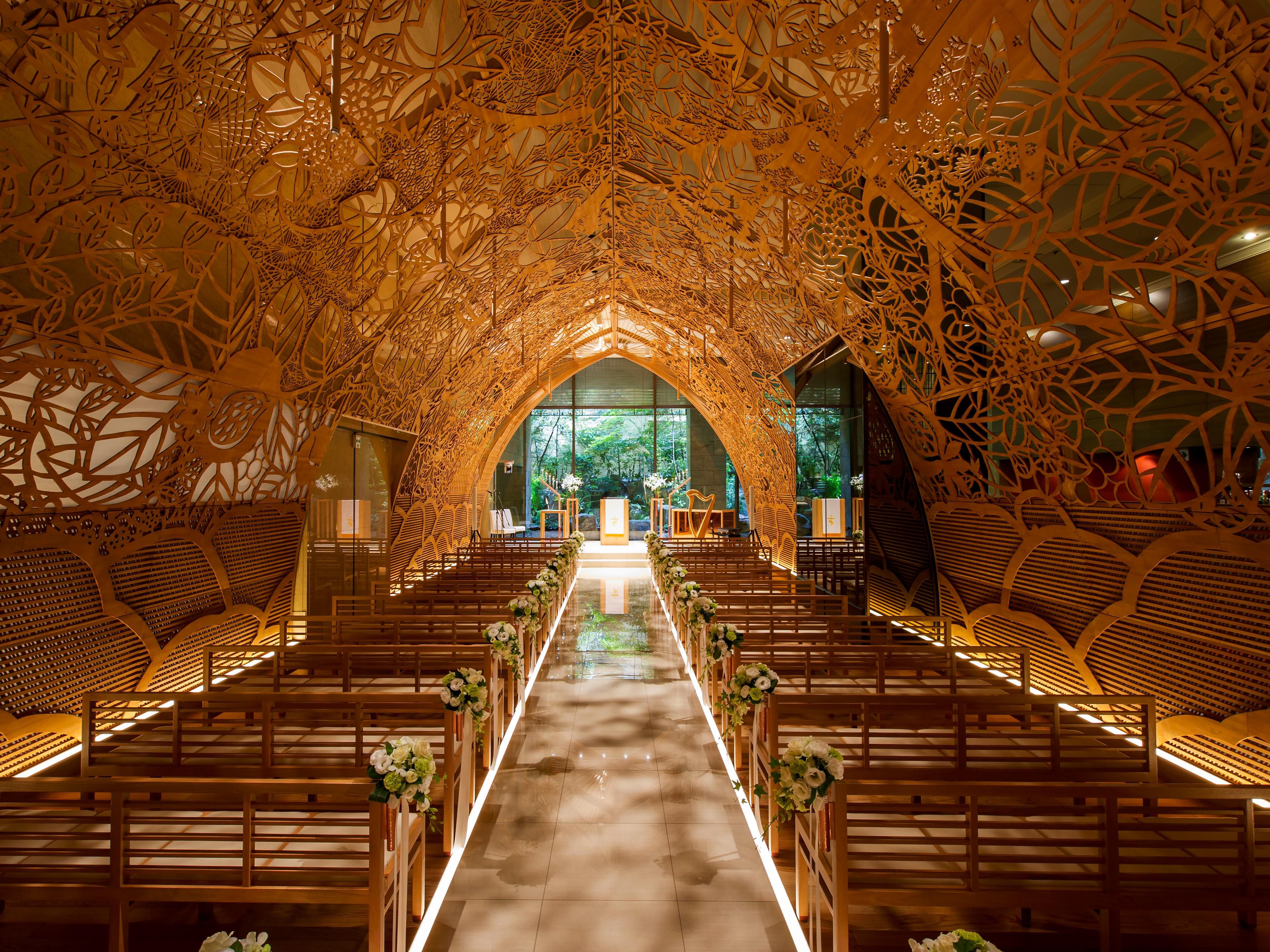 A gently sunlit aisle and flourished greenery behind the altar has a woods like atmosphere. In the pure and comfortable space created by the harmony with art and nature, the ceremony is a celebration surrounded by the power of life and warmth of the guests.