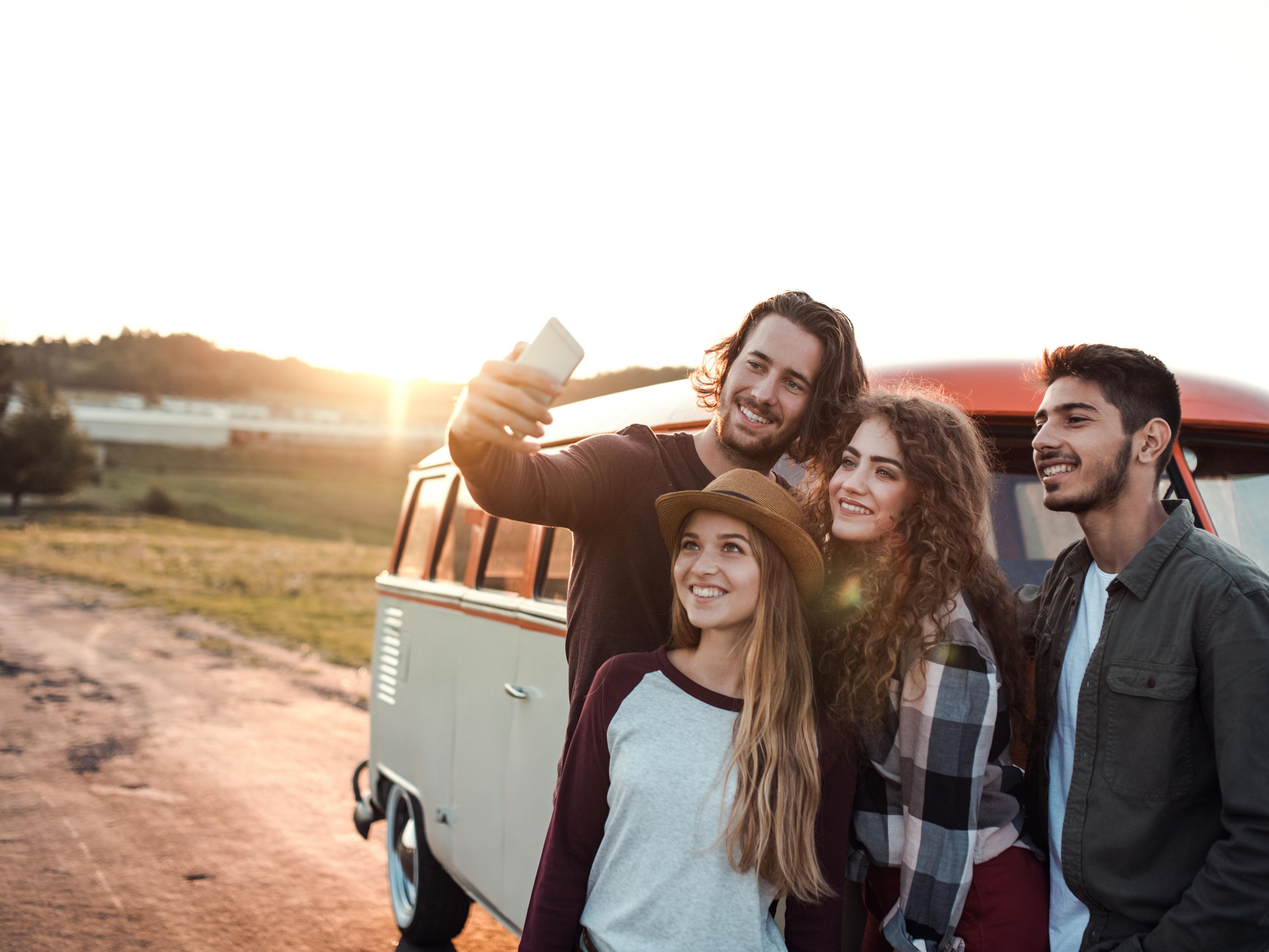 family standing in front of a van taking a selfie