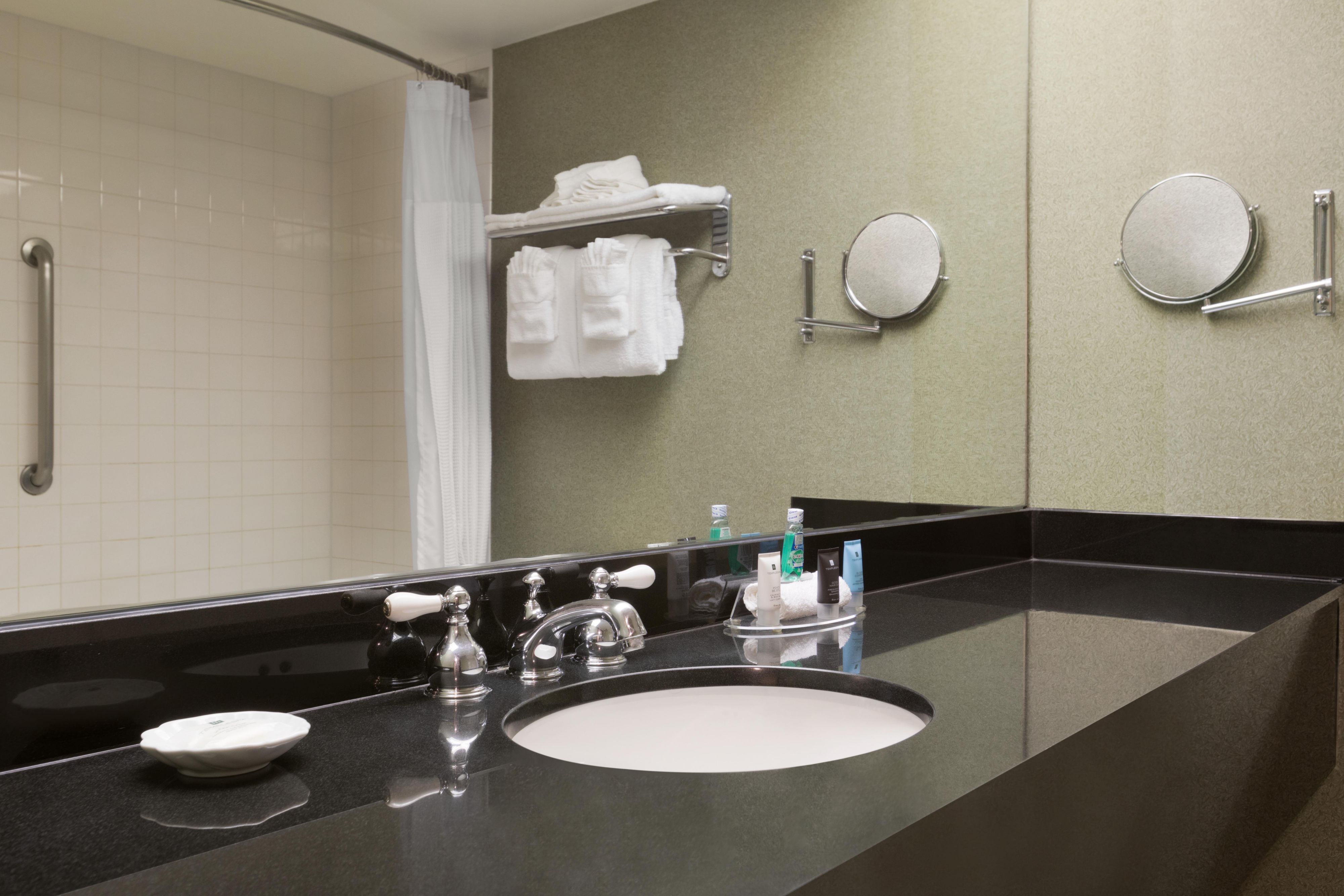 Guest bathrooms feature large, well-lit vanities and fresh linens.