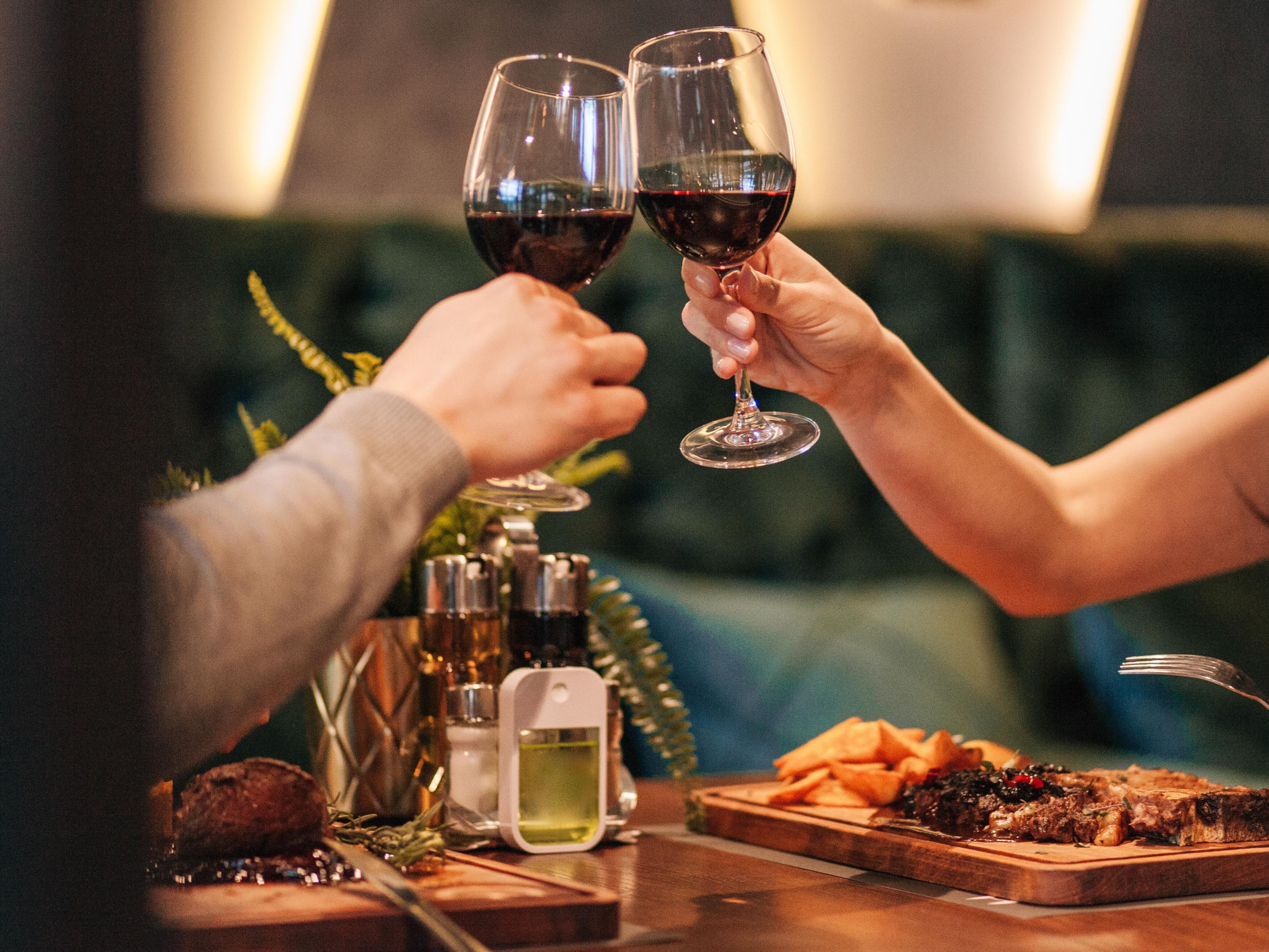 Cheers with wine glasses over dinner
