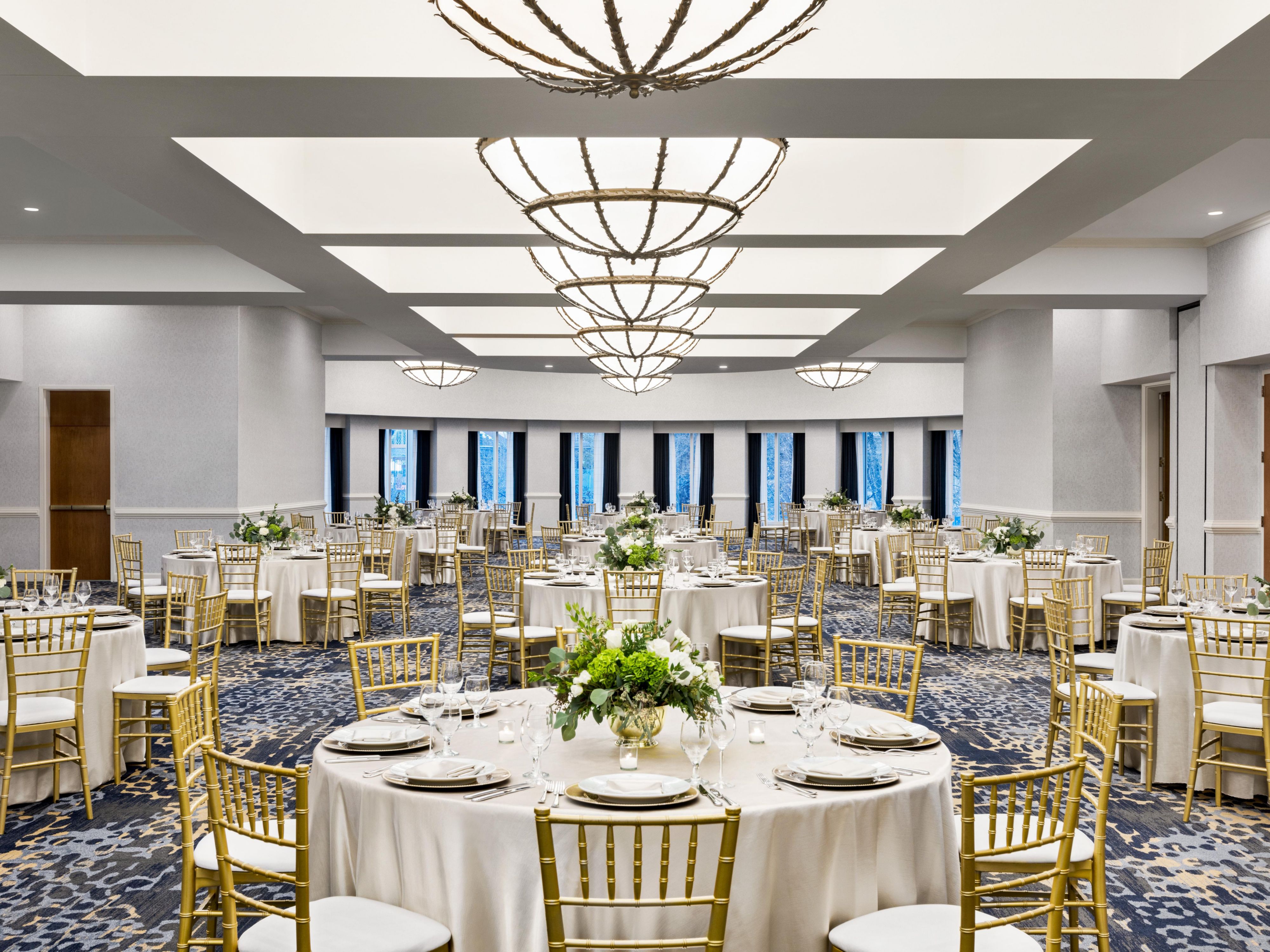 Event ballroom set up with round tables and decor.