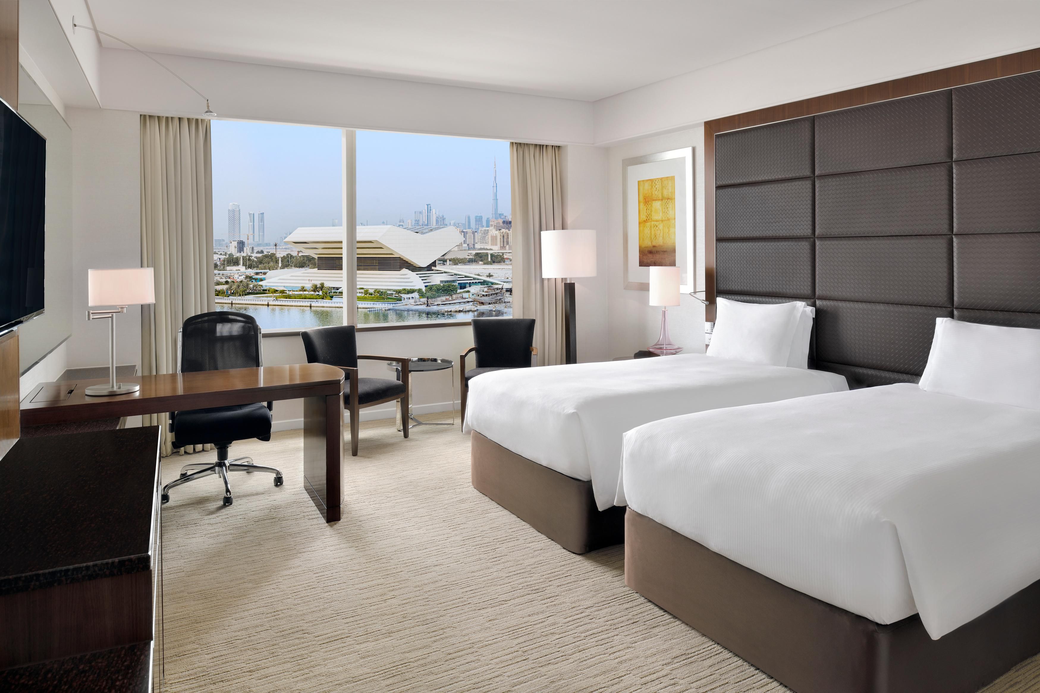 Twin bedrooms with waterfront Dubai skyline views