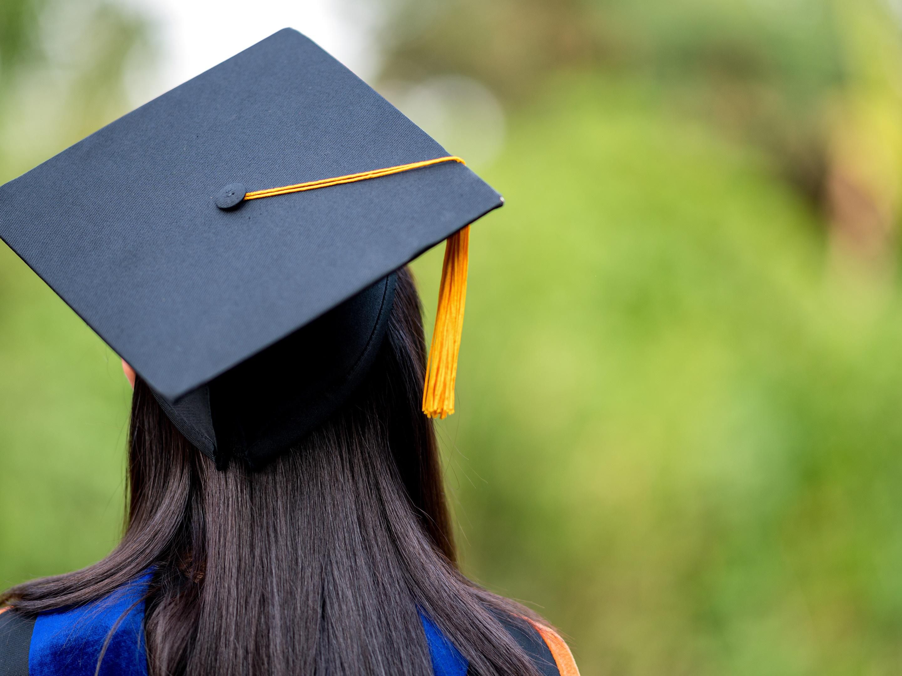 graduate standing with graduation cap