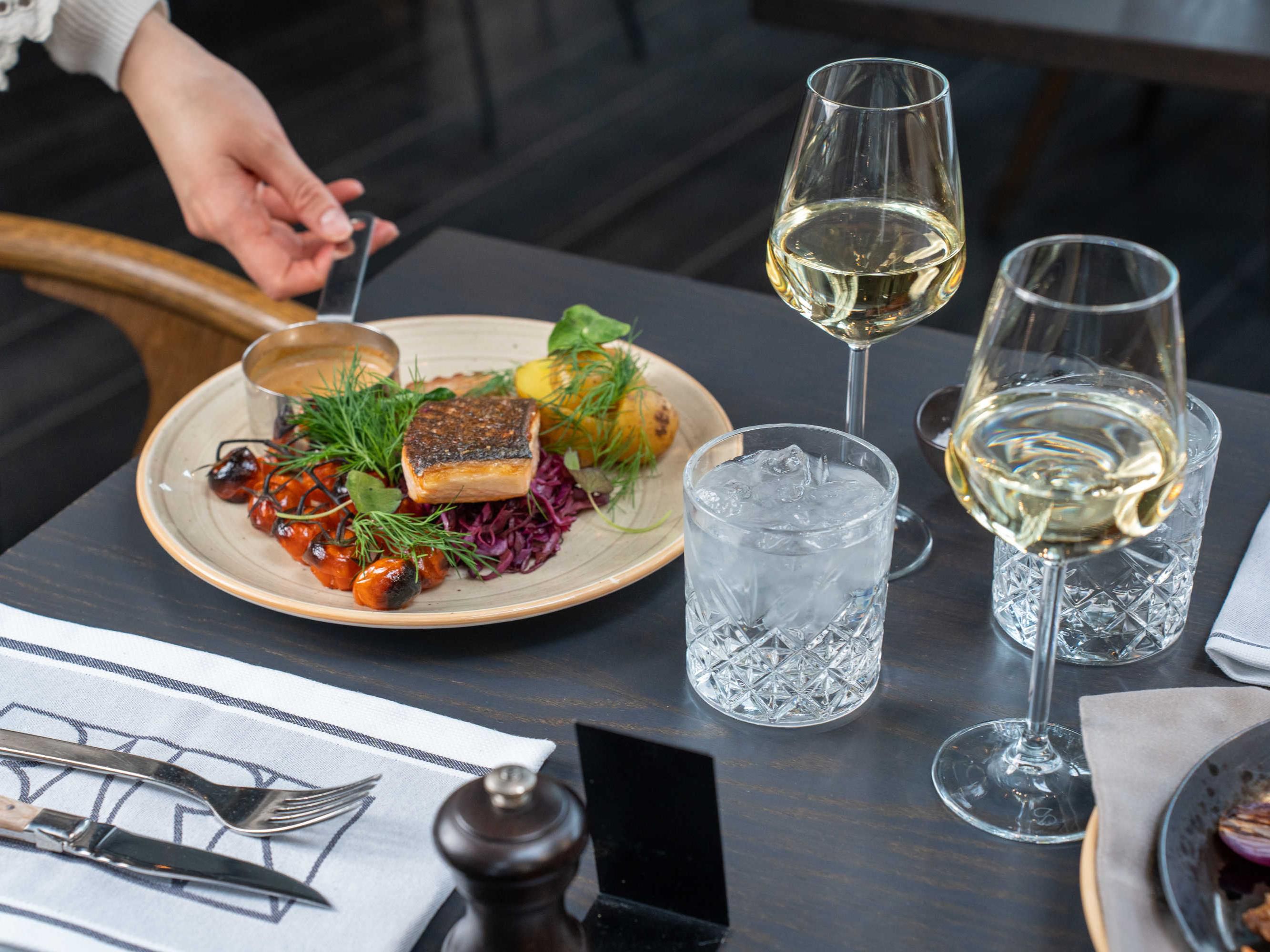 Plate being served and wine glasses