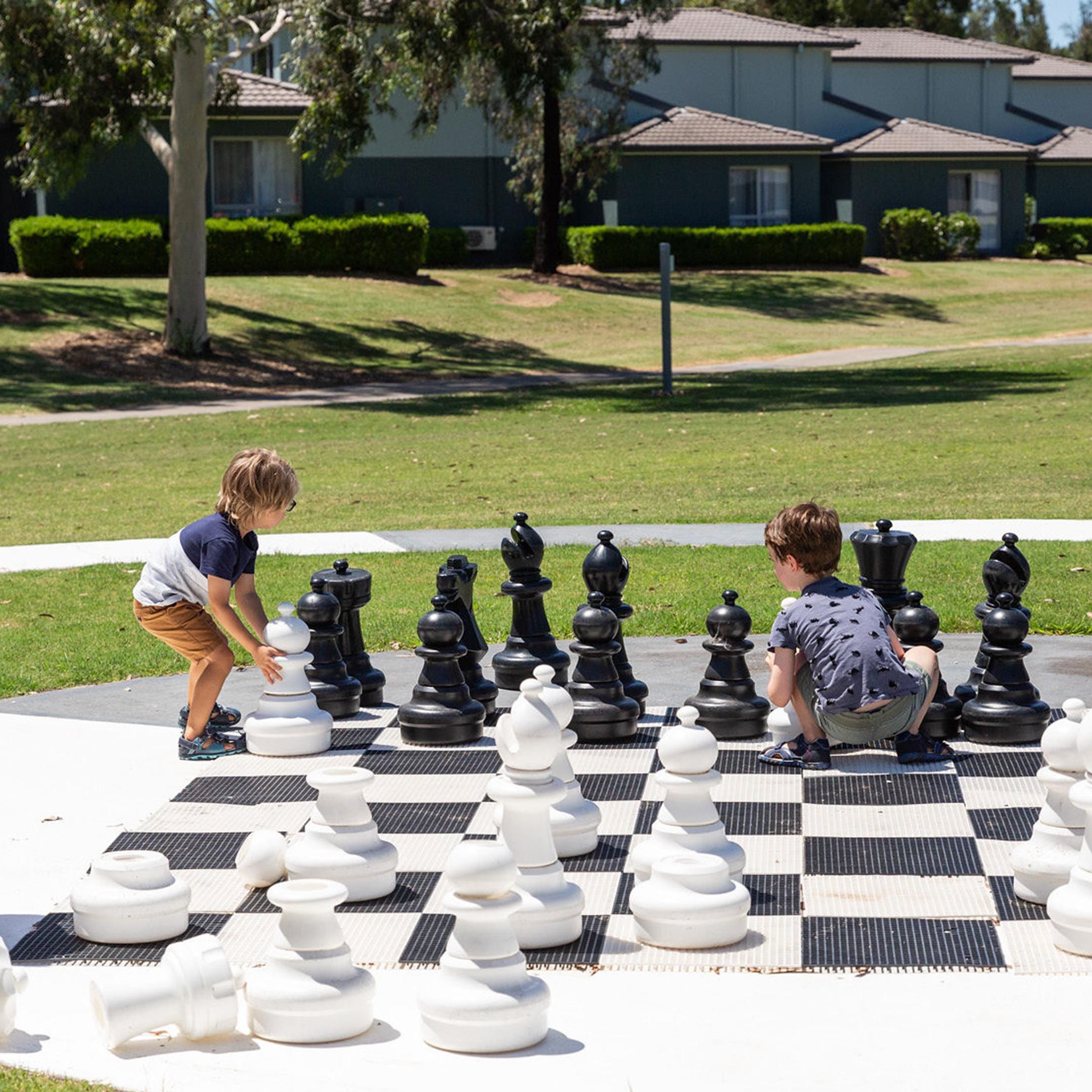 Playing giant chess on the resort&#39;s activities lawn
