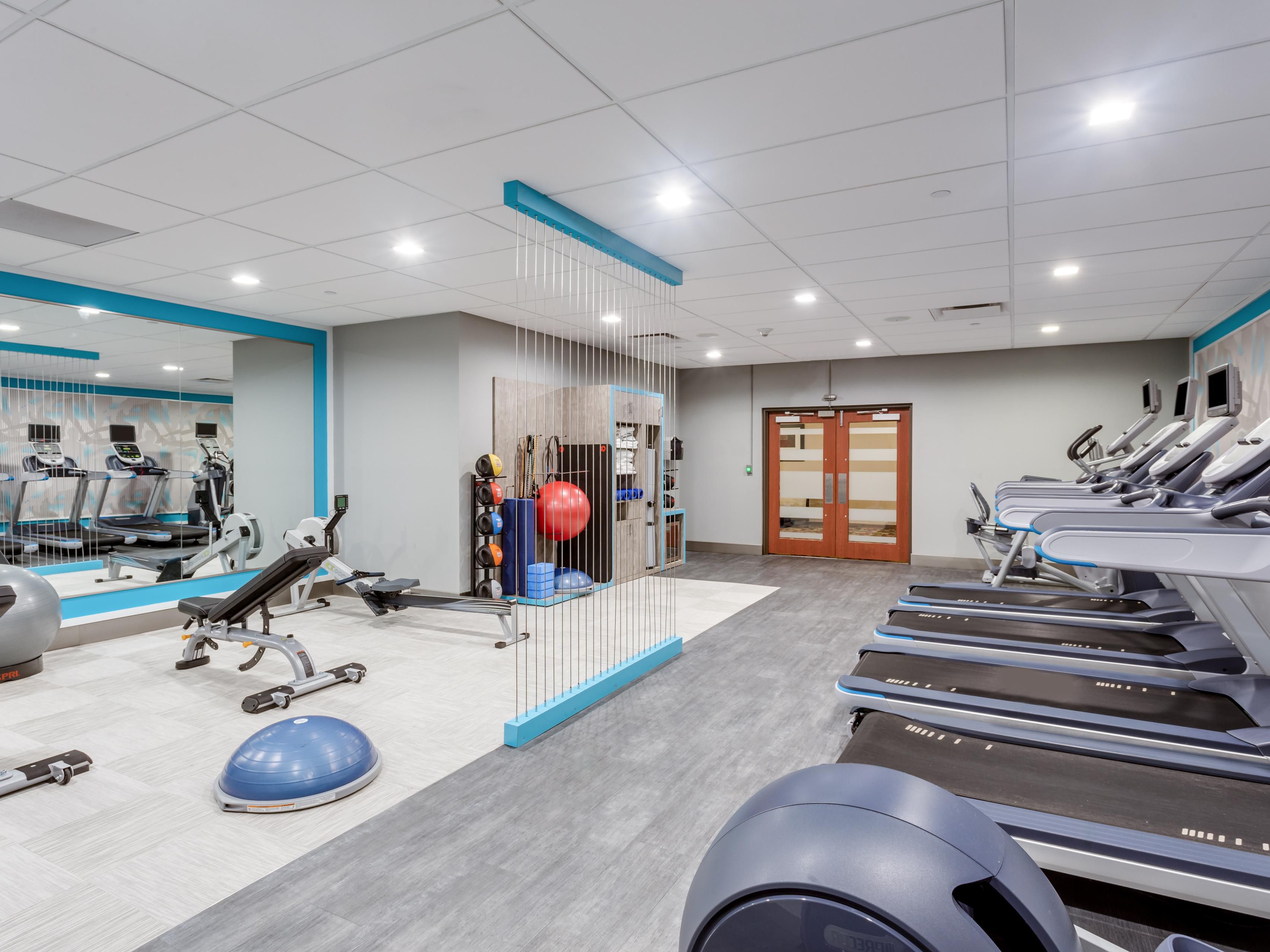 fitness center with cardio equipment and weights