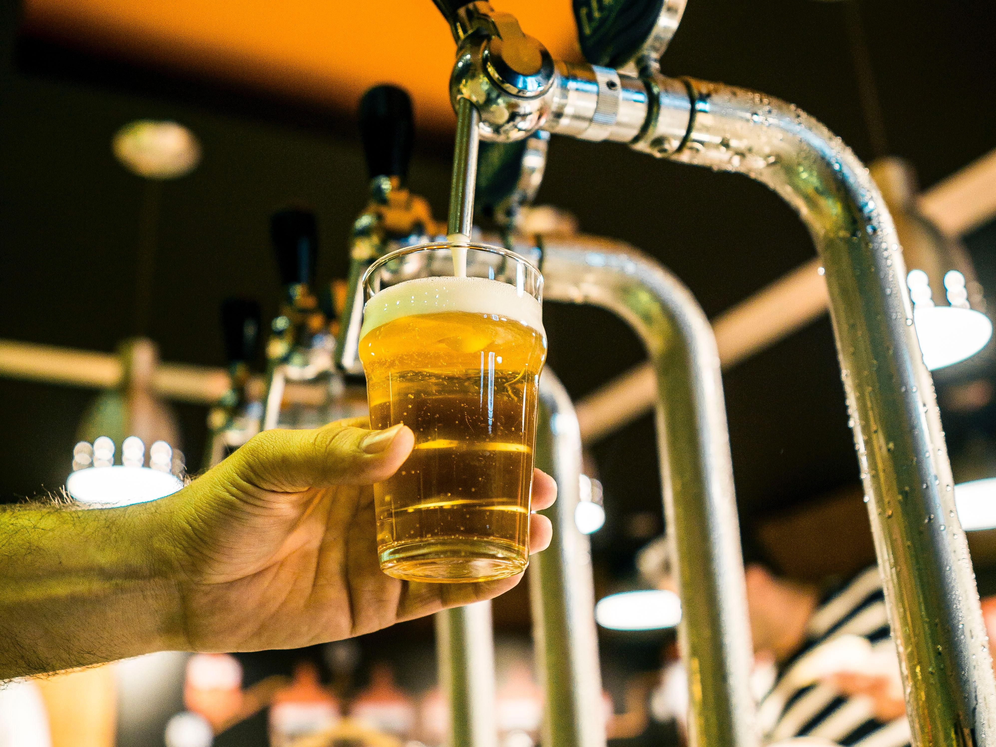 pouring beer into a glass at a brewery