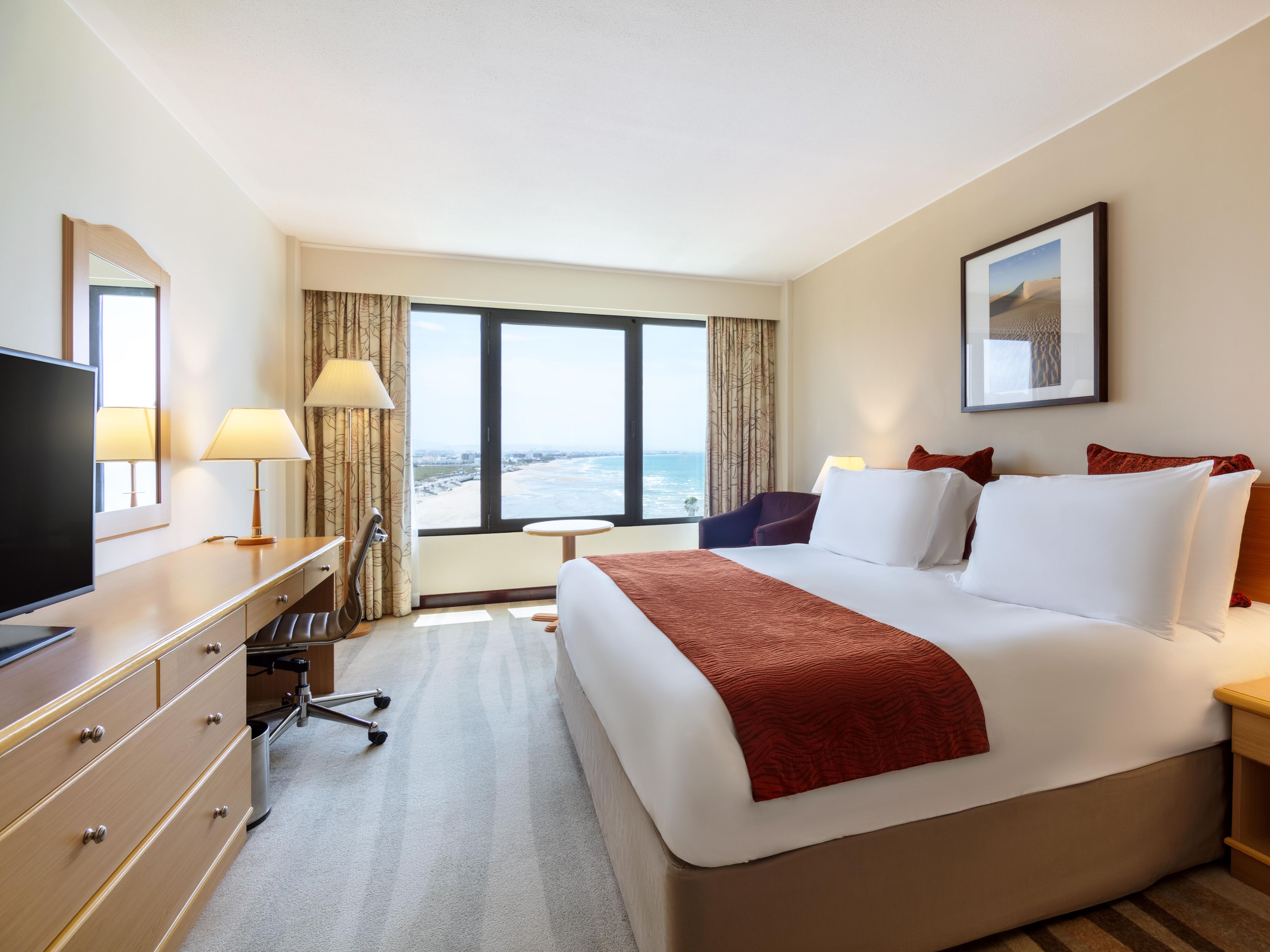 Walk into a spacious room with stunning views of the Gulf of Oman