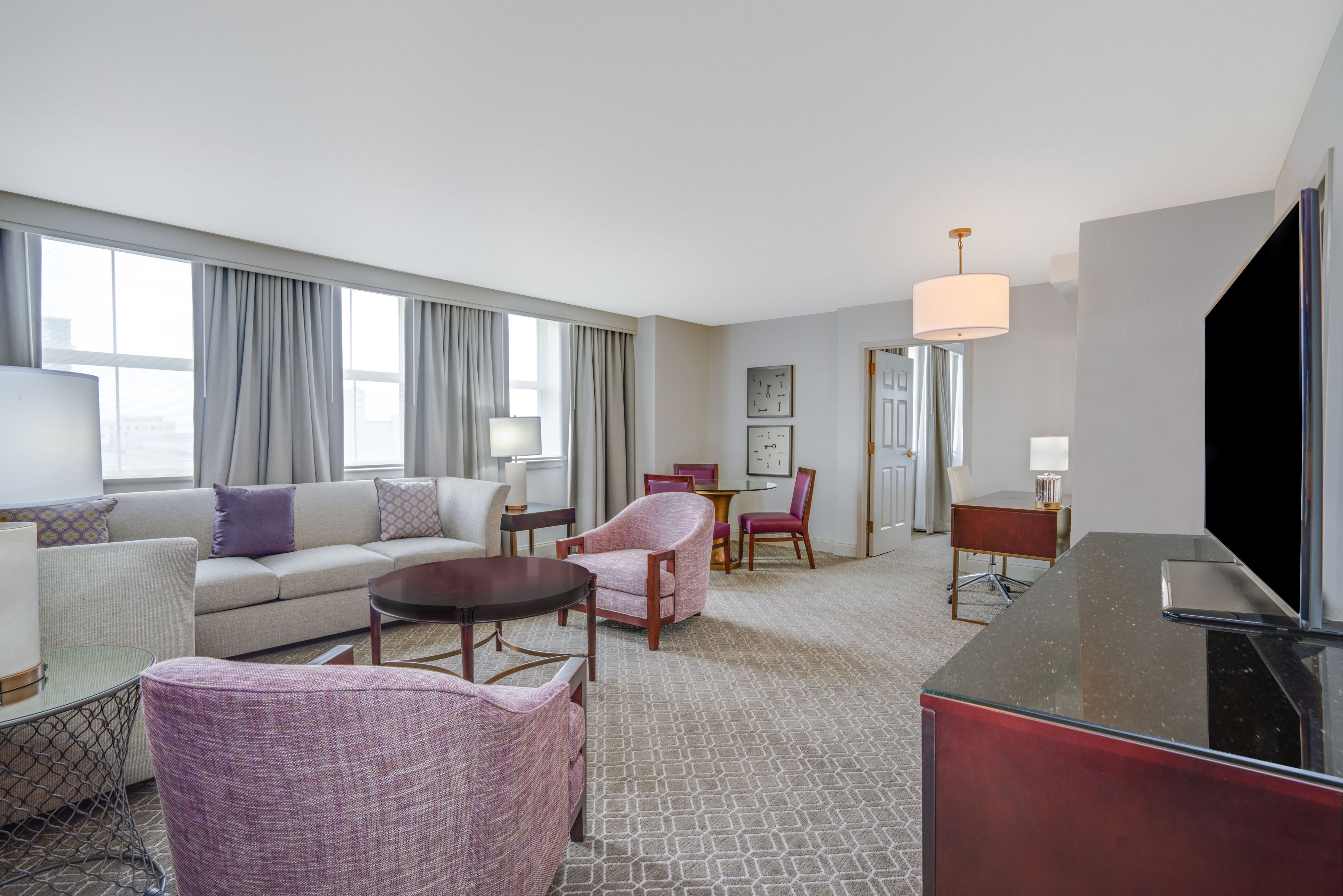 Living room and dining room in hotel room suite.