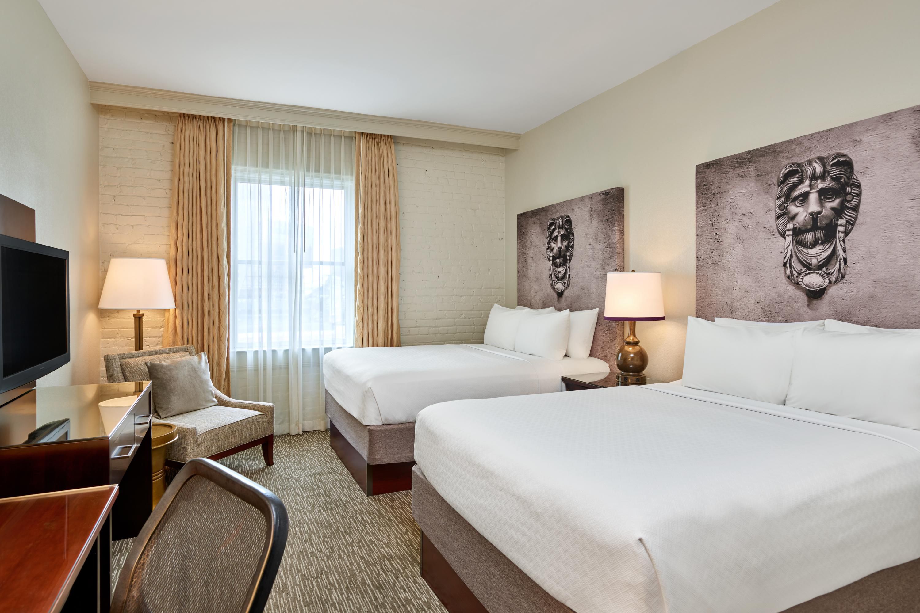 Standard queen room with two queen beds, a desk, and chair.