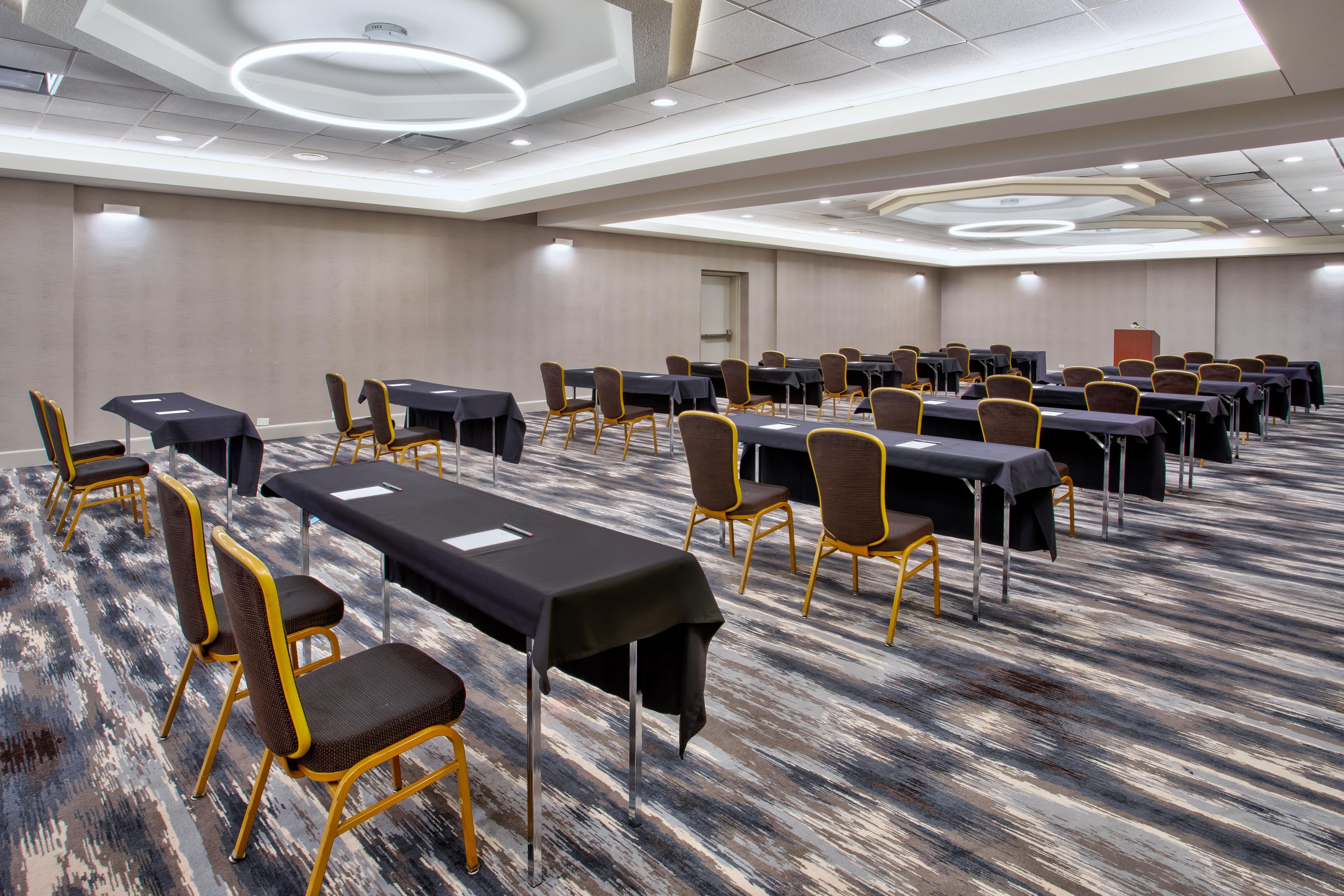 Large event space with multiple tables set for 2 guests each 
