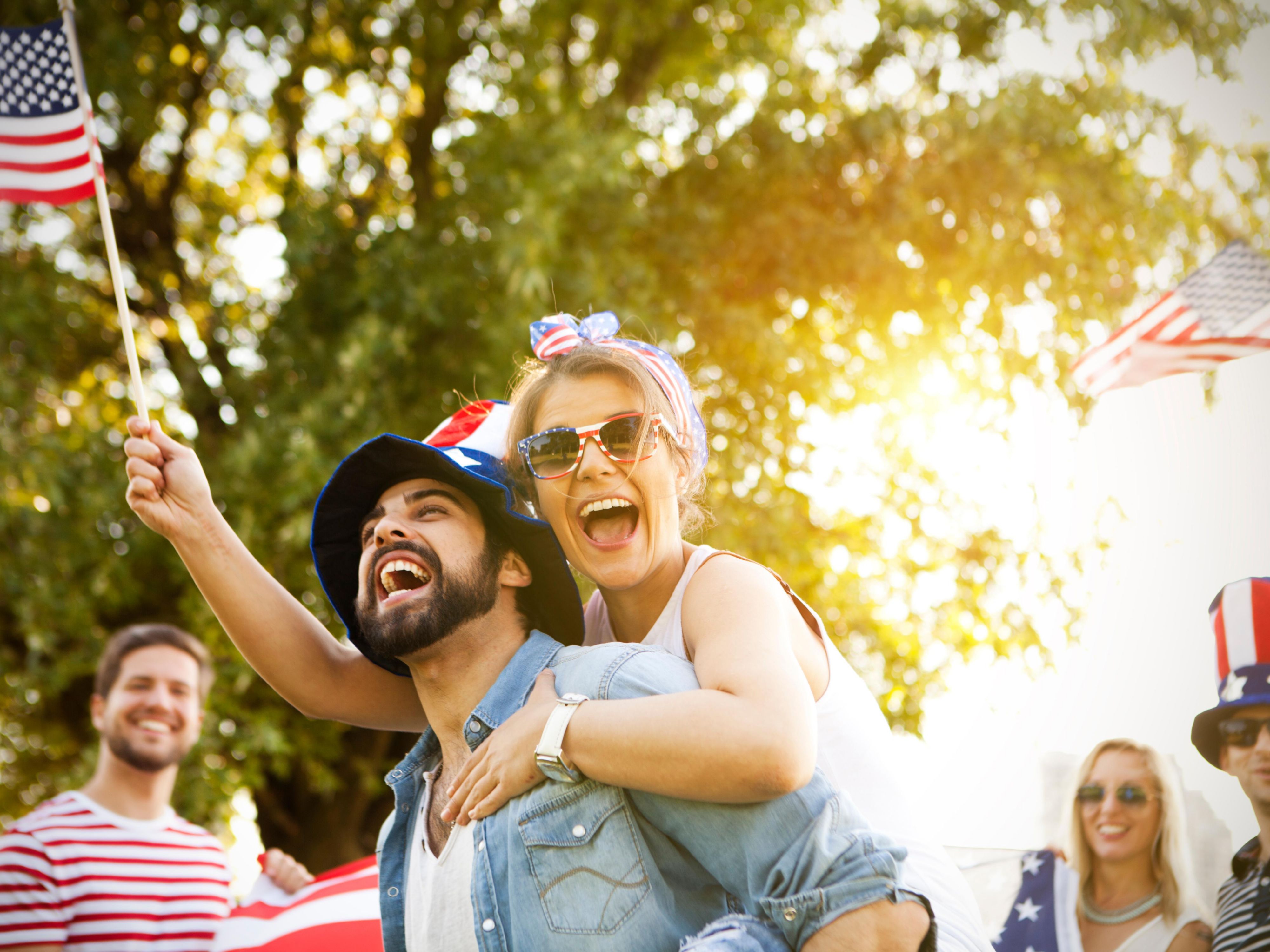 people with us flags smiling and happy