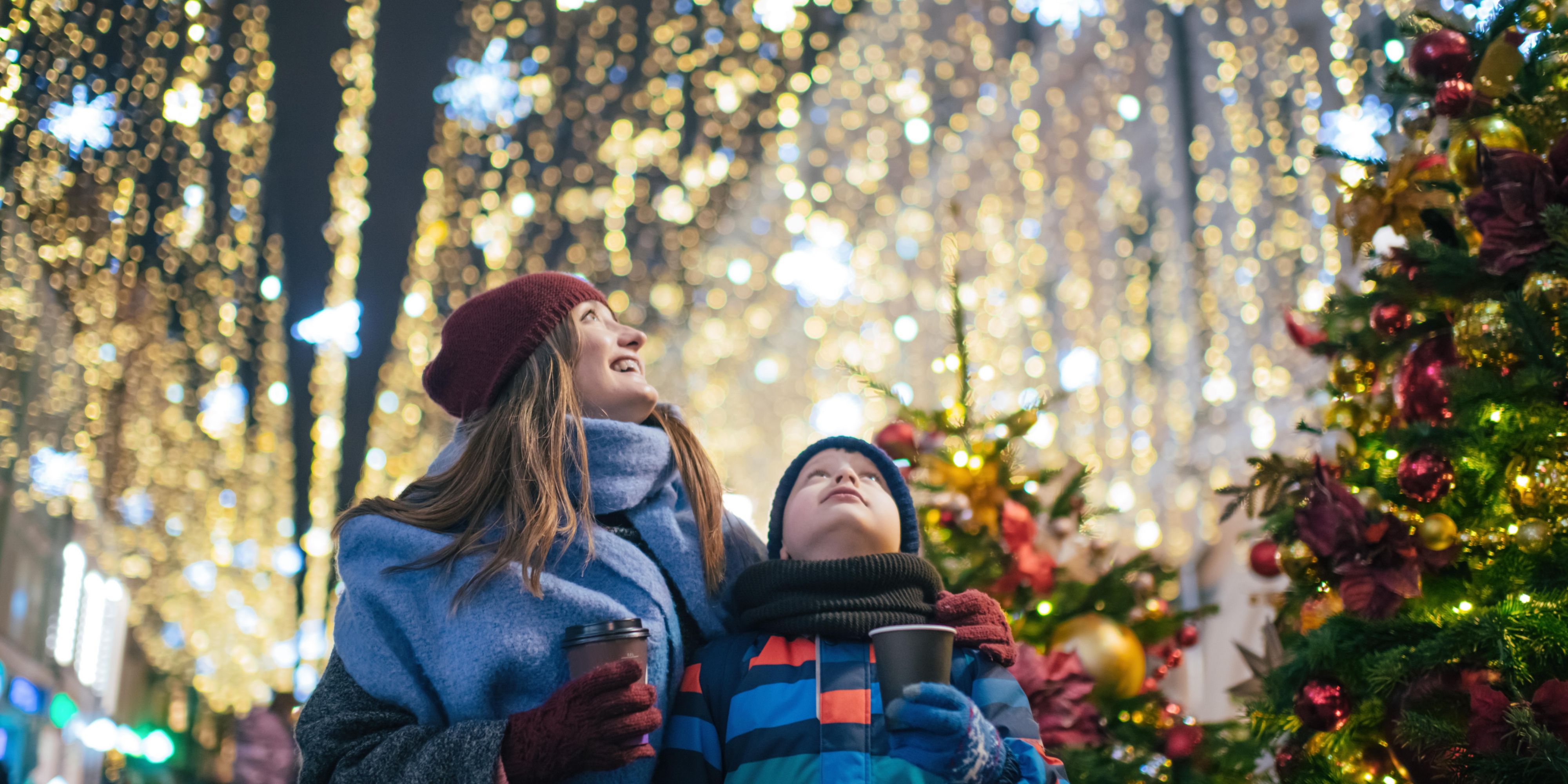 Mom and son strolling through Christmas lights