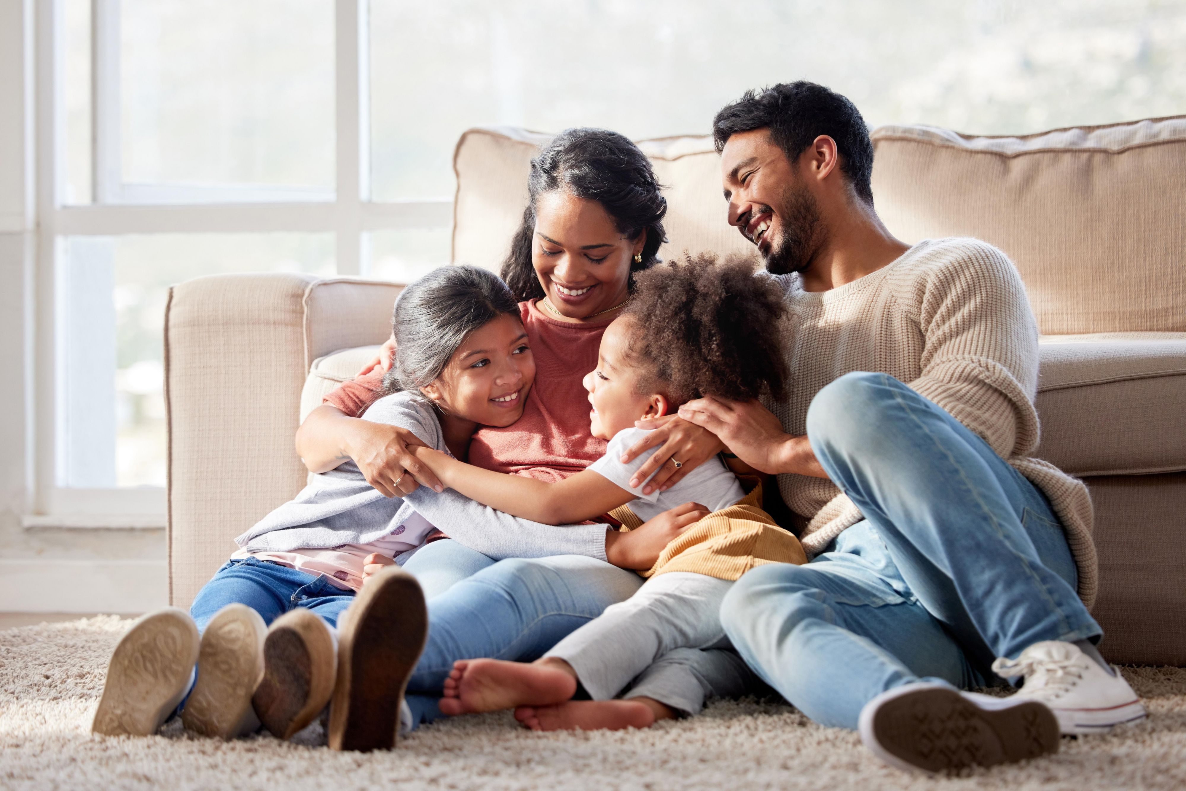 Family laughing and sitting on floor together