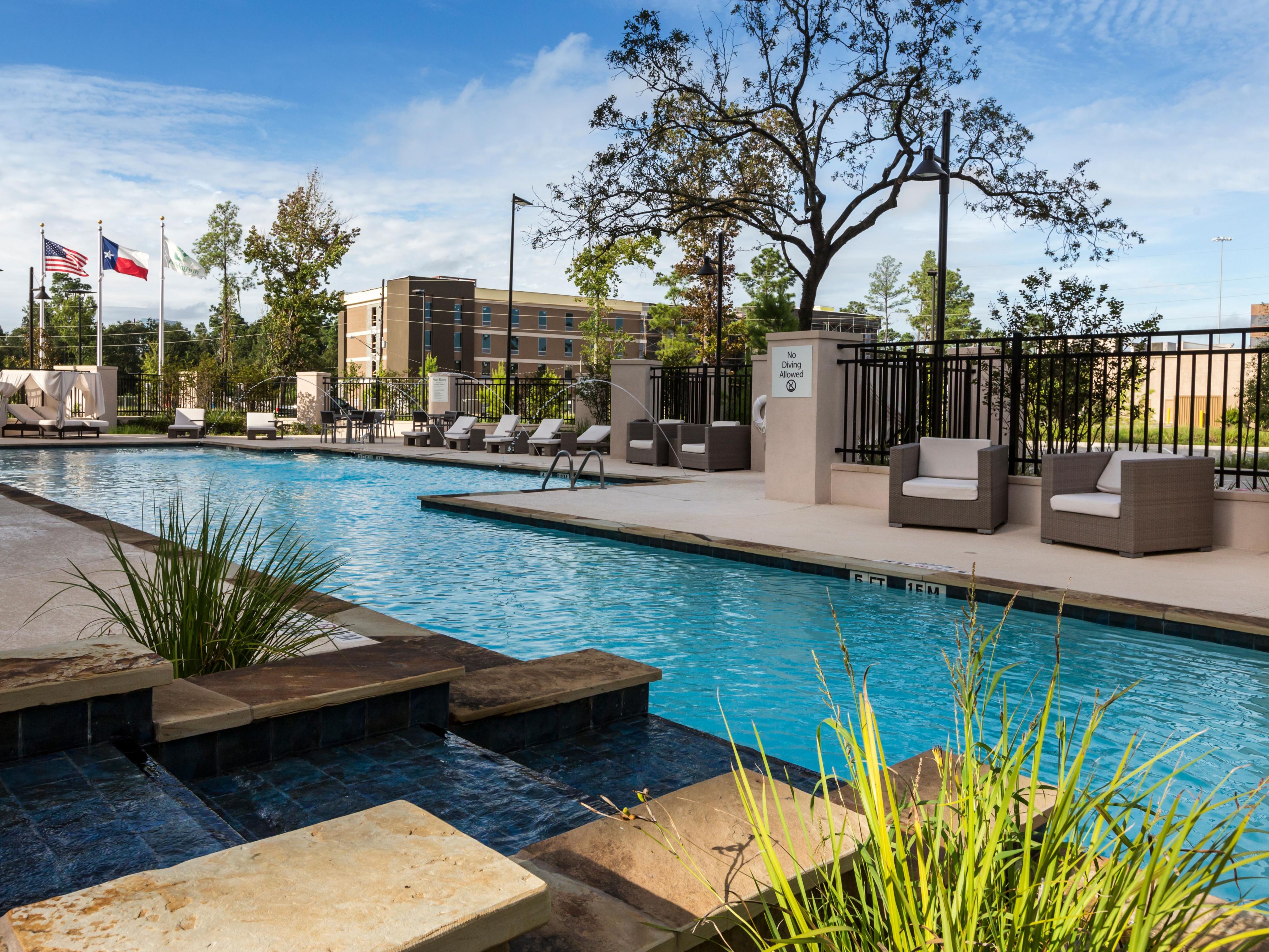Poolside at Crowne Plaza Shenandoah Woodlands Area with seating.