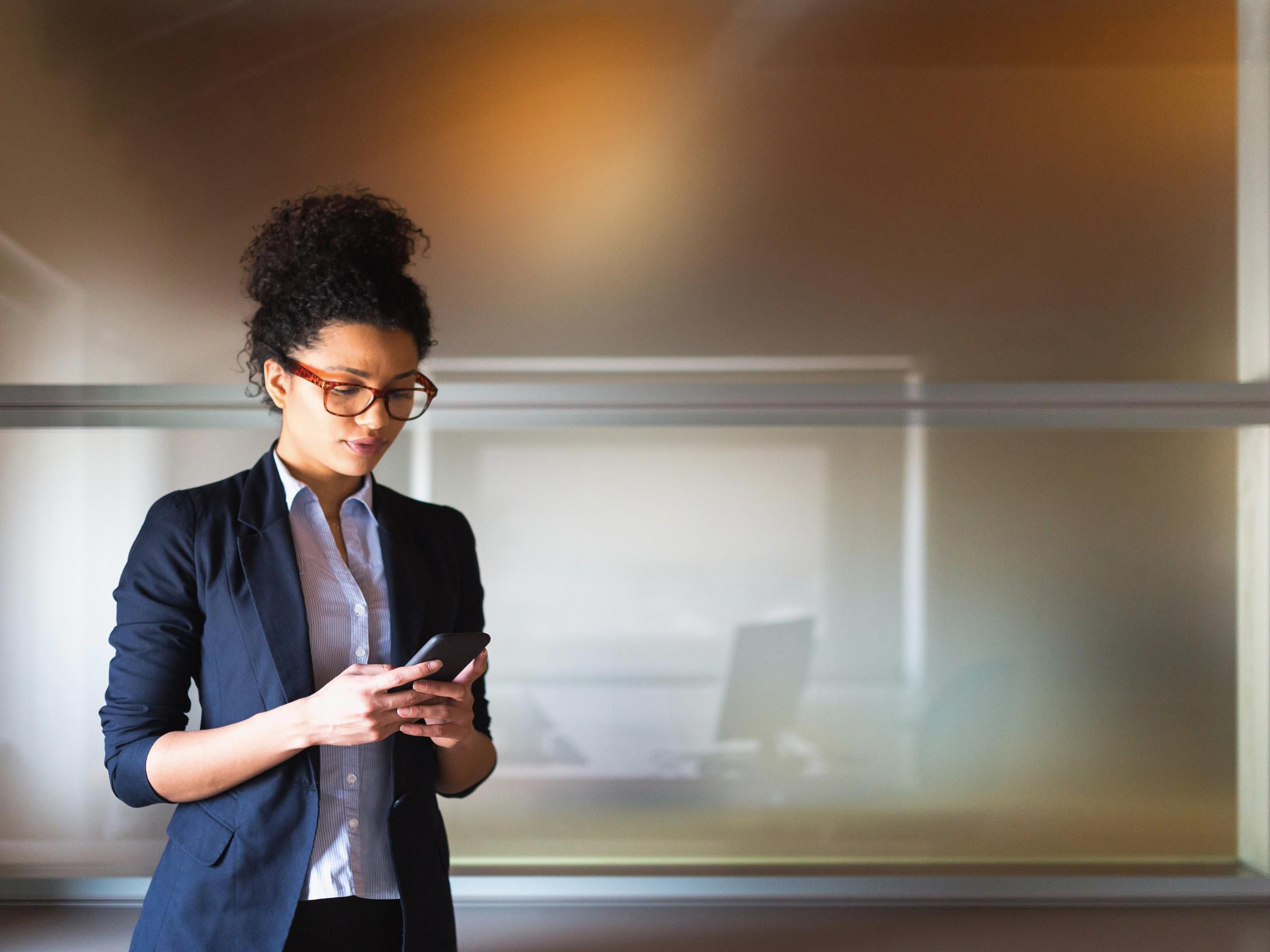 Woman checking phone in corporate setting