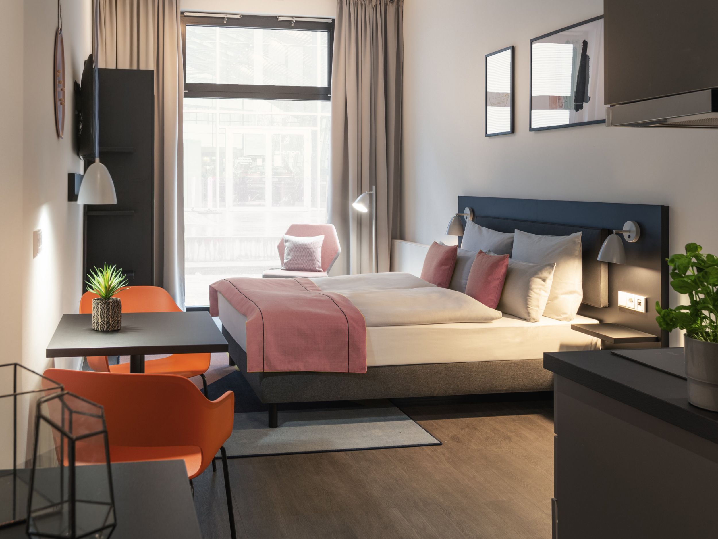 Hotelschlafzimmer mit Kingsize-Bett, Fernseher, Schreibtisch und Stuhl