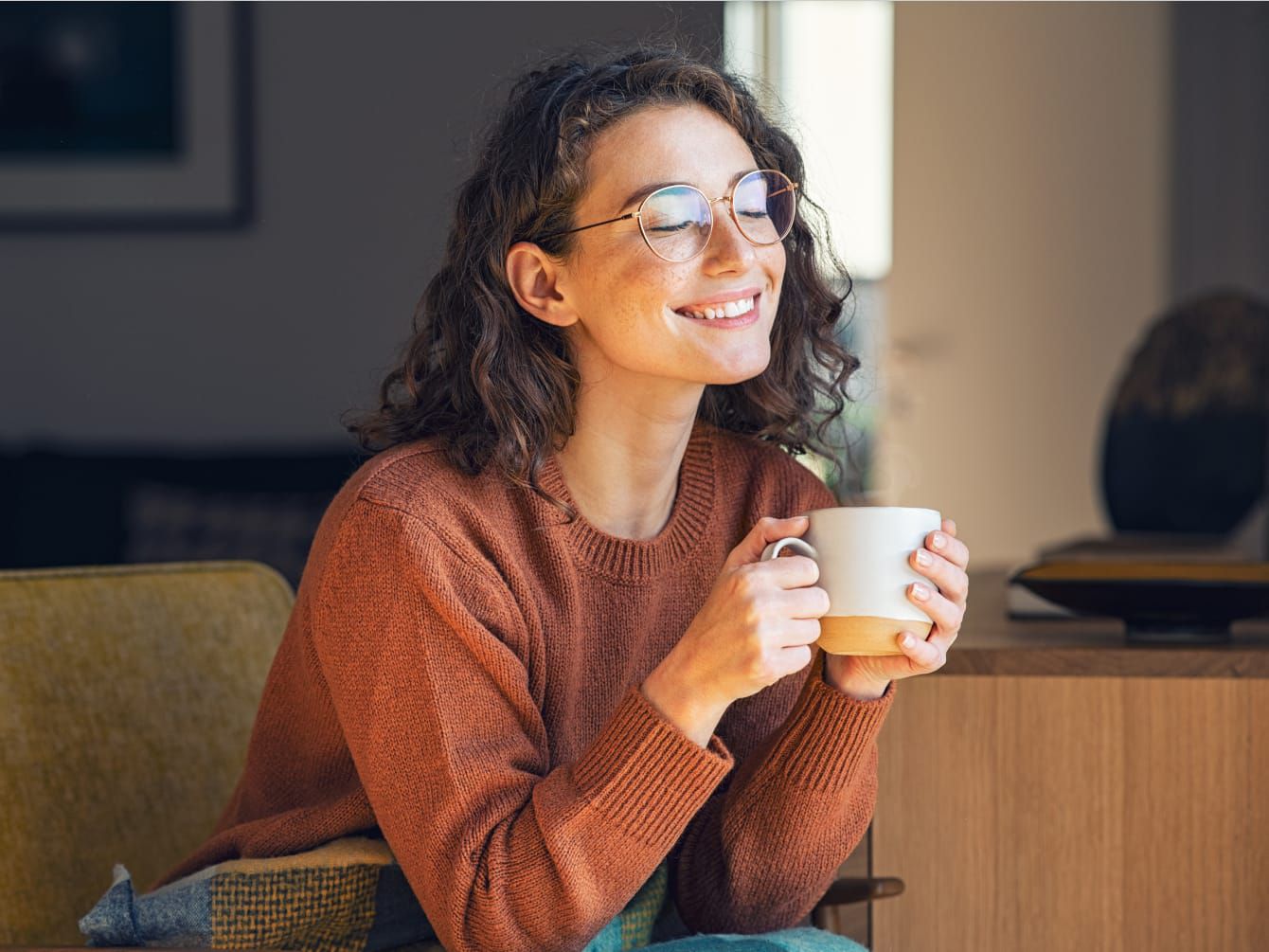 Woman smiling and drinking coffee