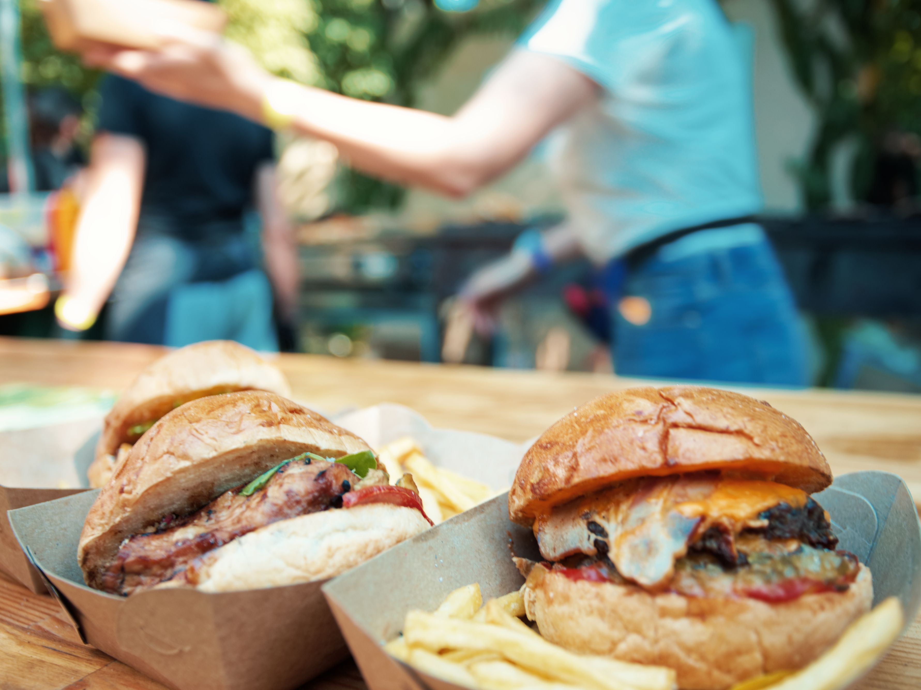 Burgers and sandwiches on a table outside