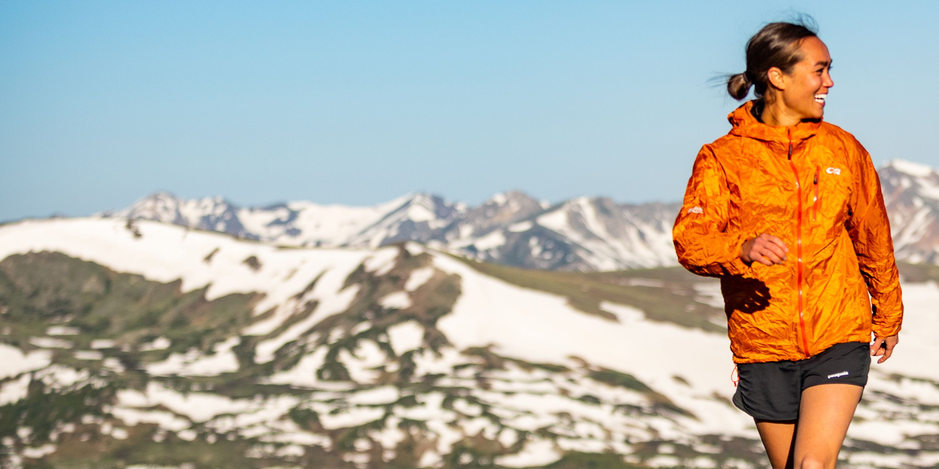 Woman running with snowy mountains in the background