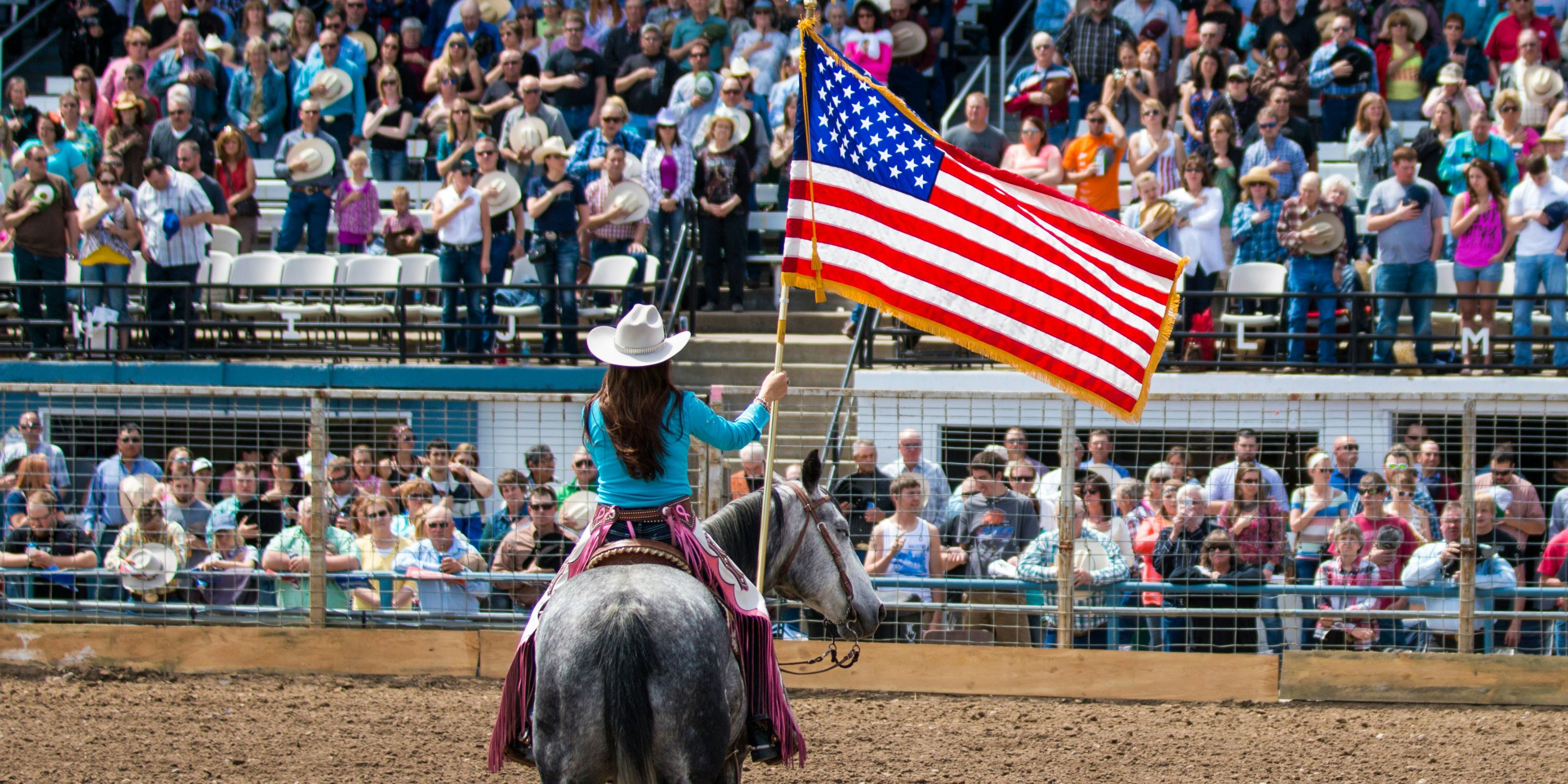 Woman on a horse holding the American flag
