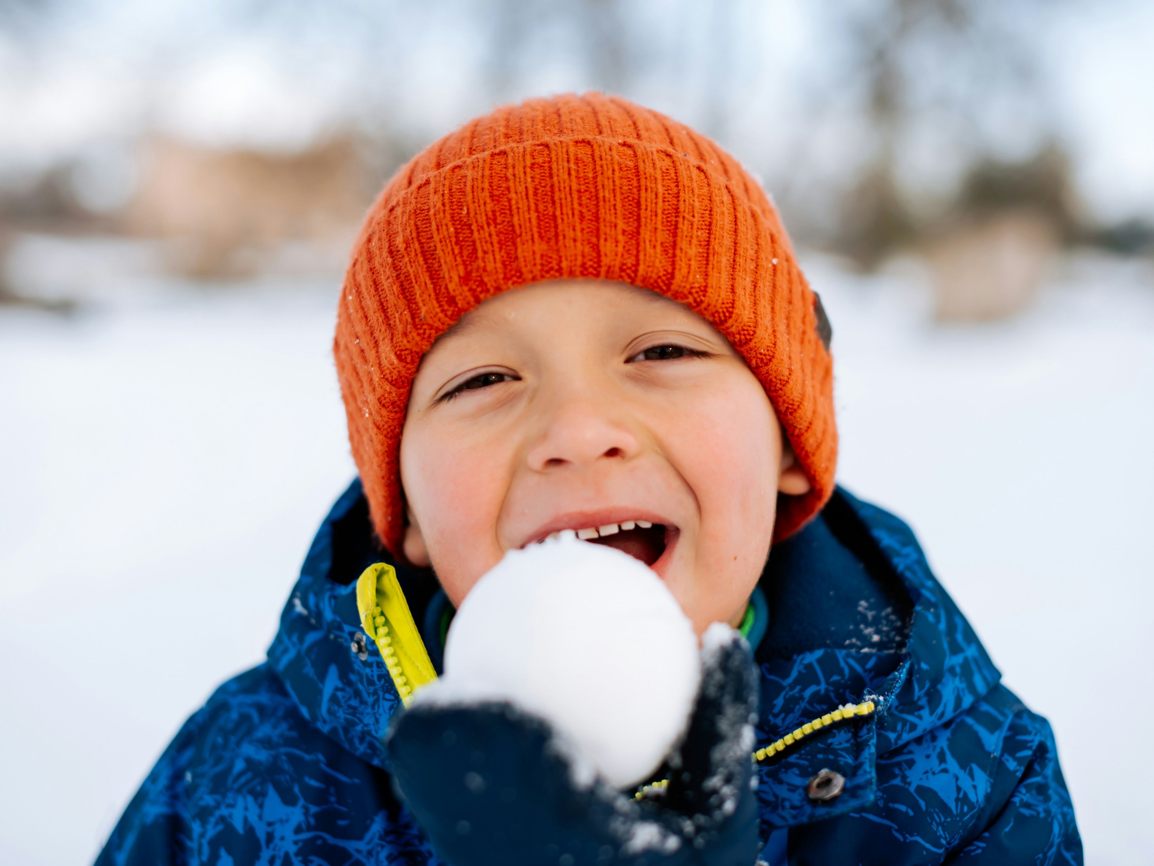 Little boy eating a snowball