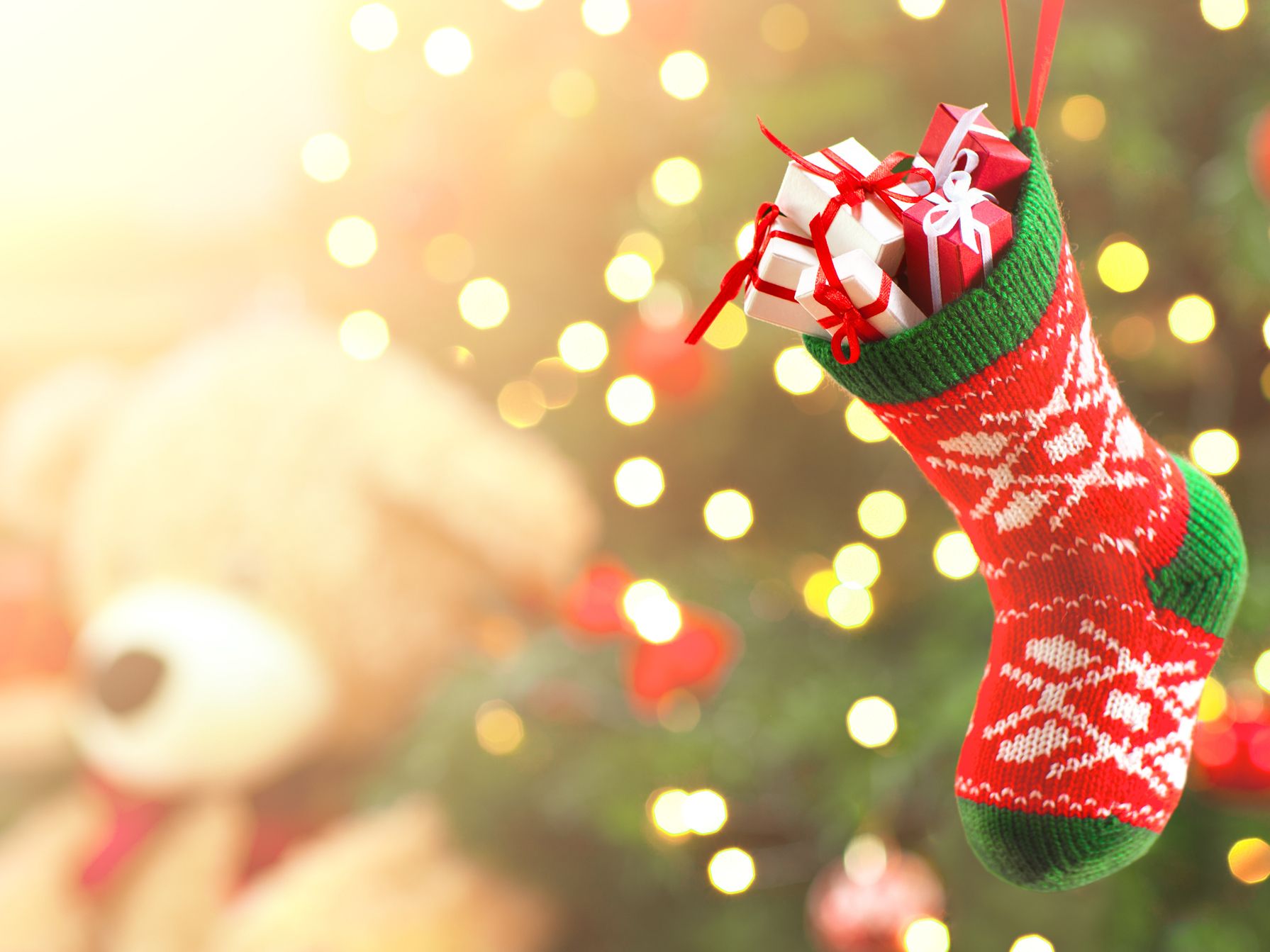 Stocking and teddy bear by christmas tree