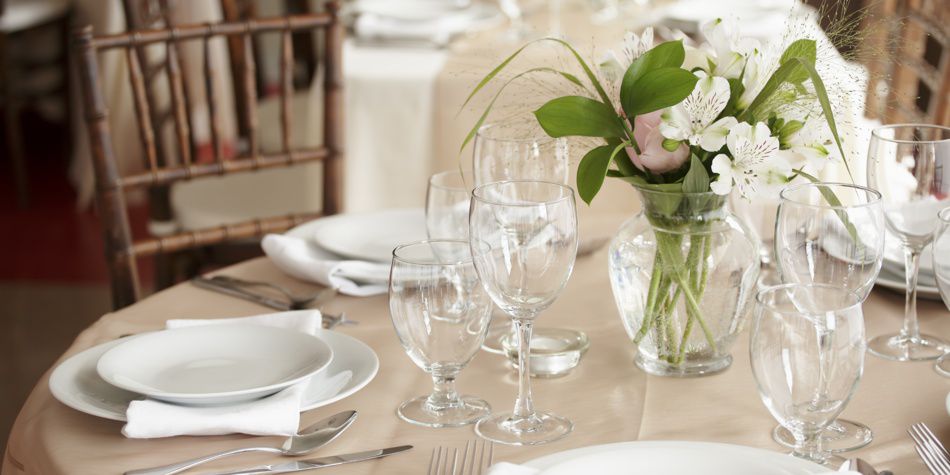 Event table setup with greenery and glassware arrangements