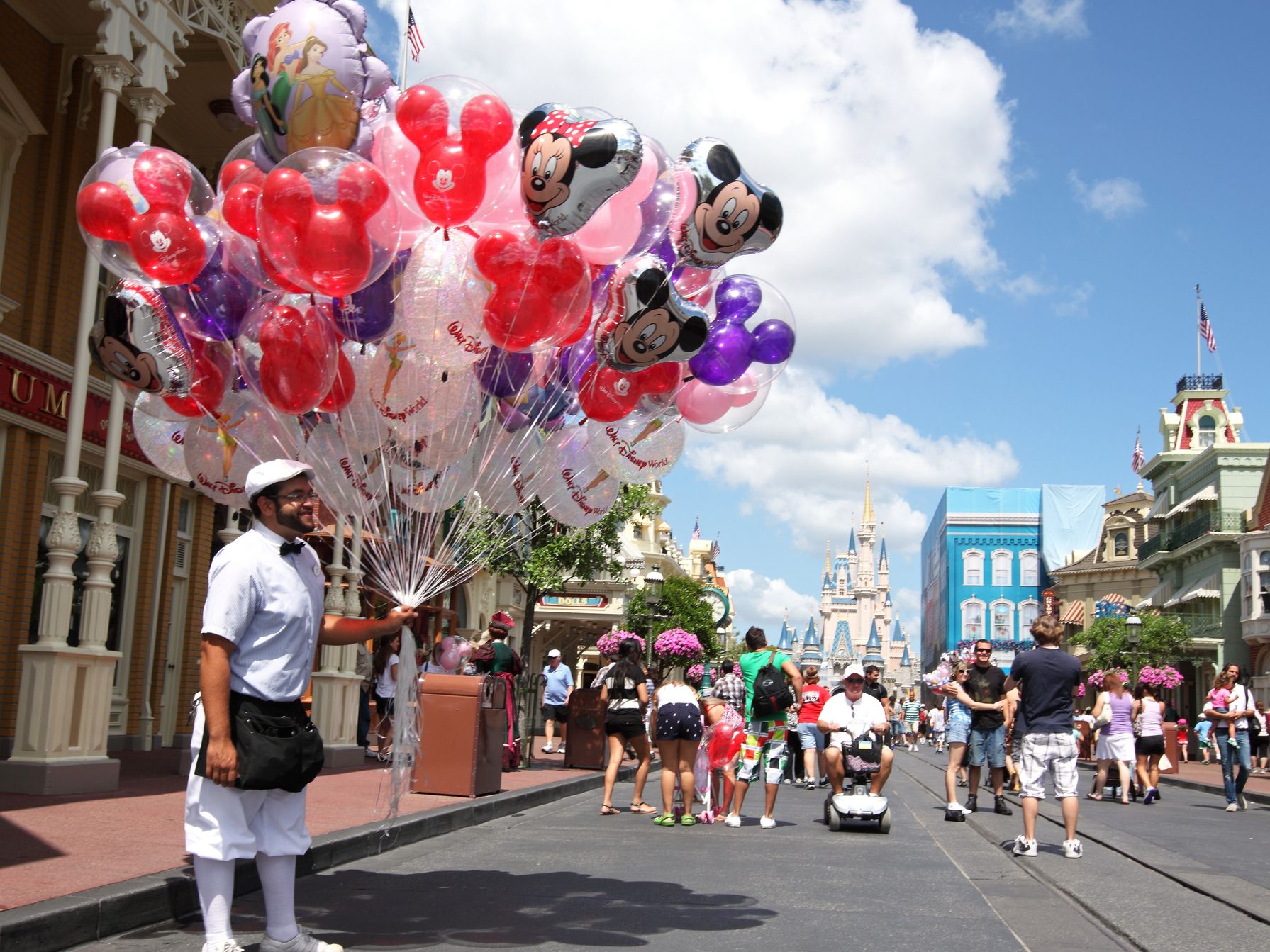 Man holding a bunch of balloons at Disneyland