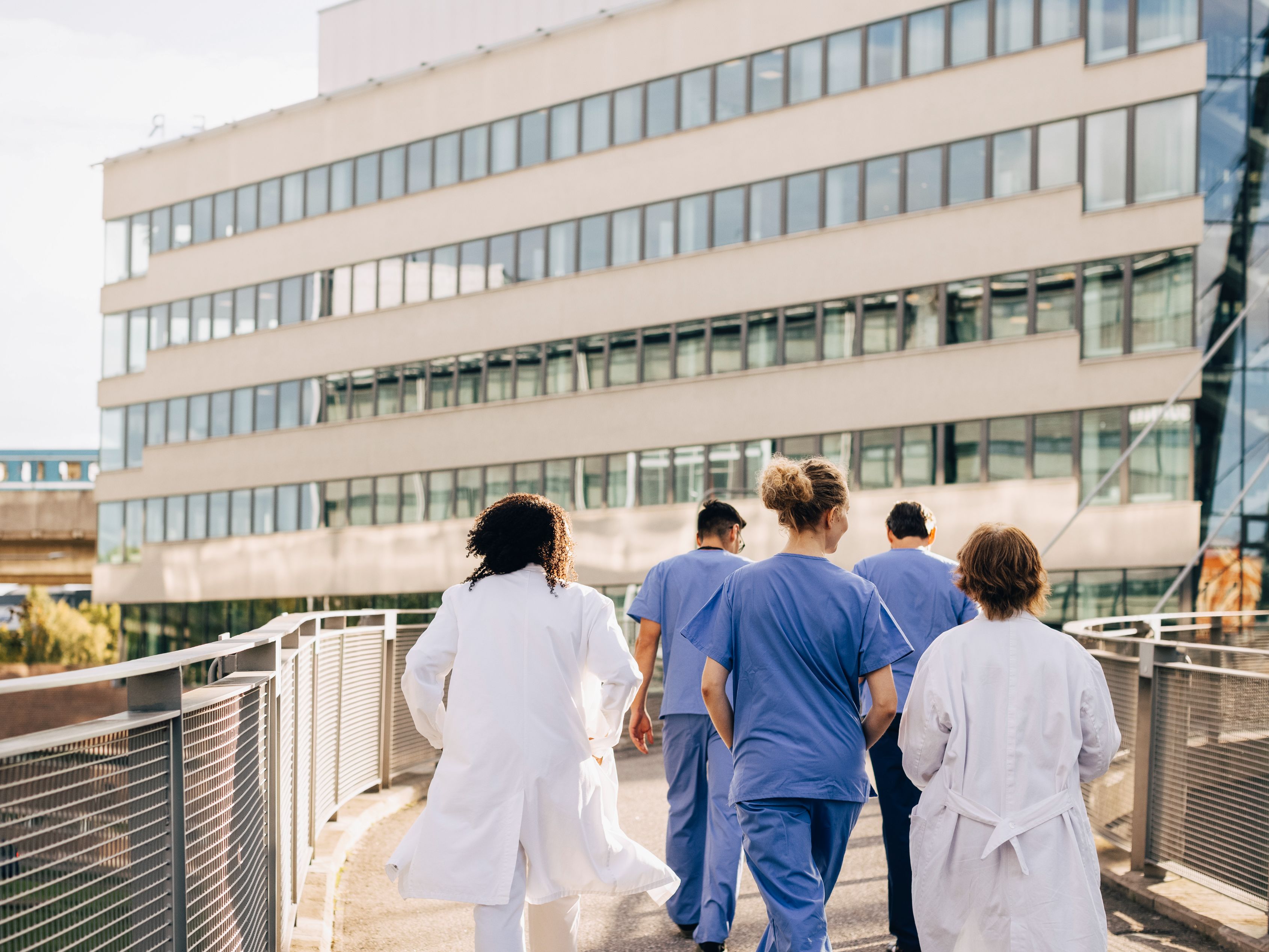 Doctors walking towards hospital building.
