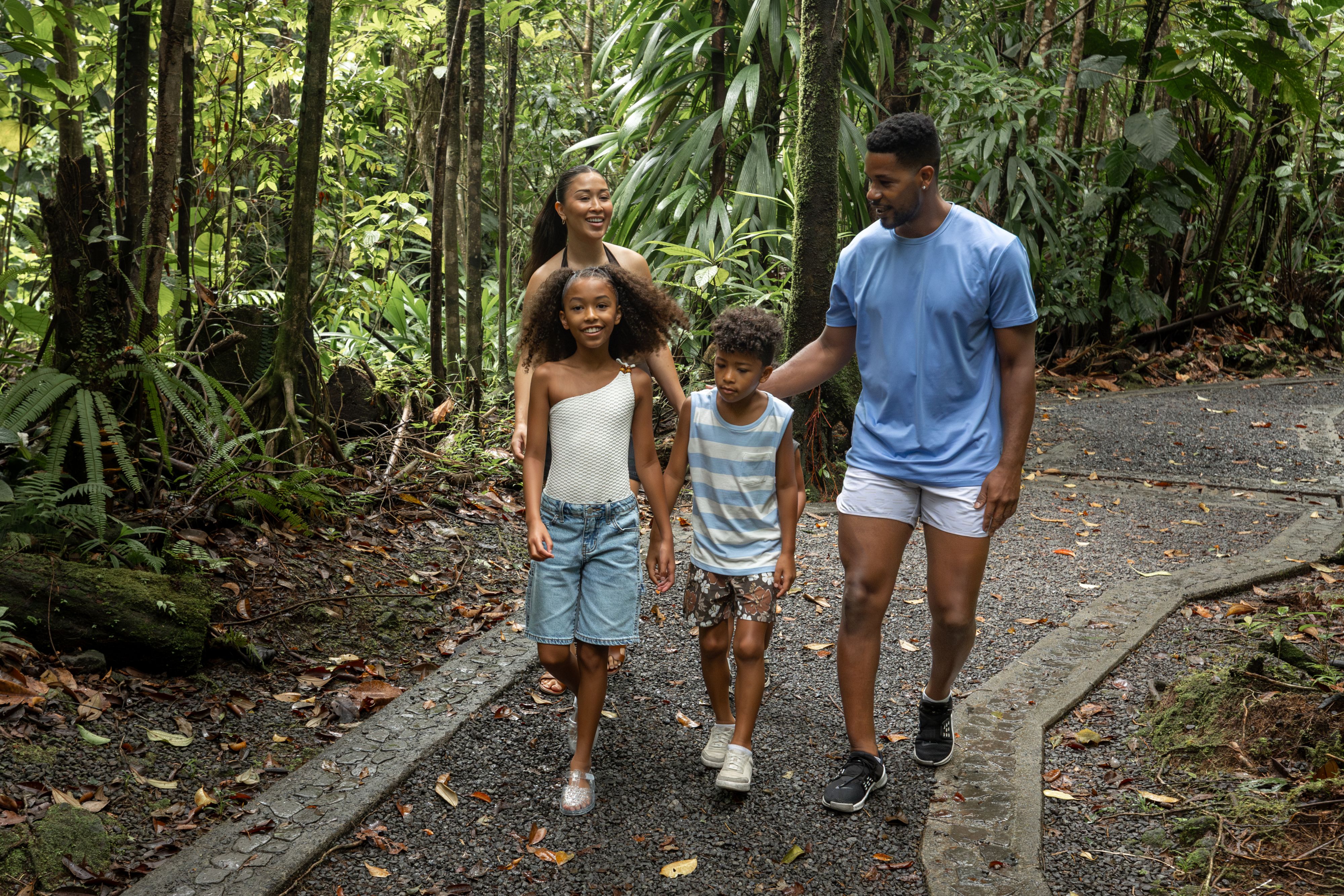 family hiking in tropical forest in dominica