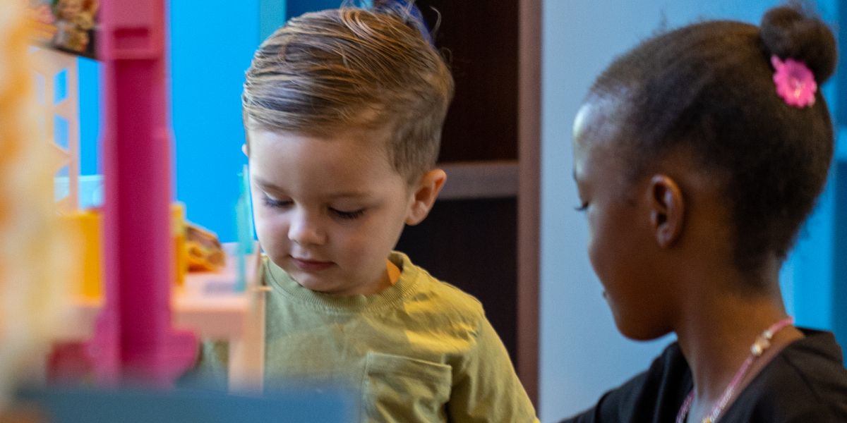 Girl and boy playing with tower of blocks