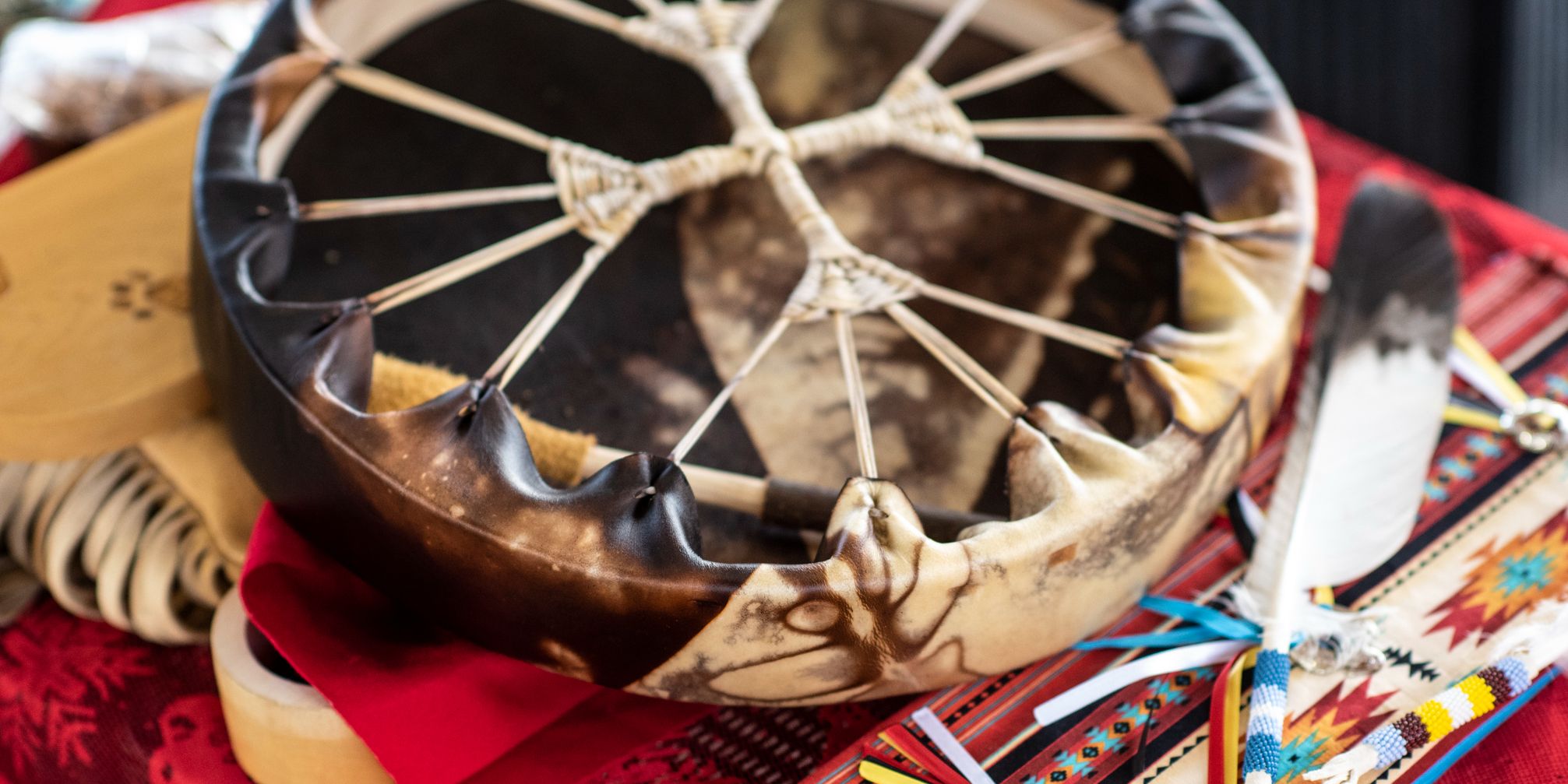 Crafted drum with feather on table