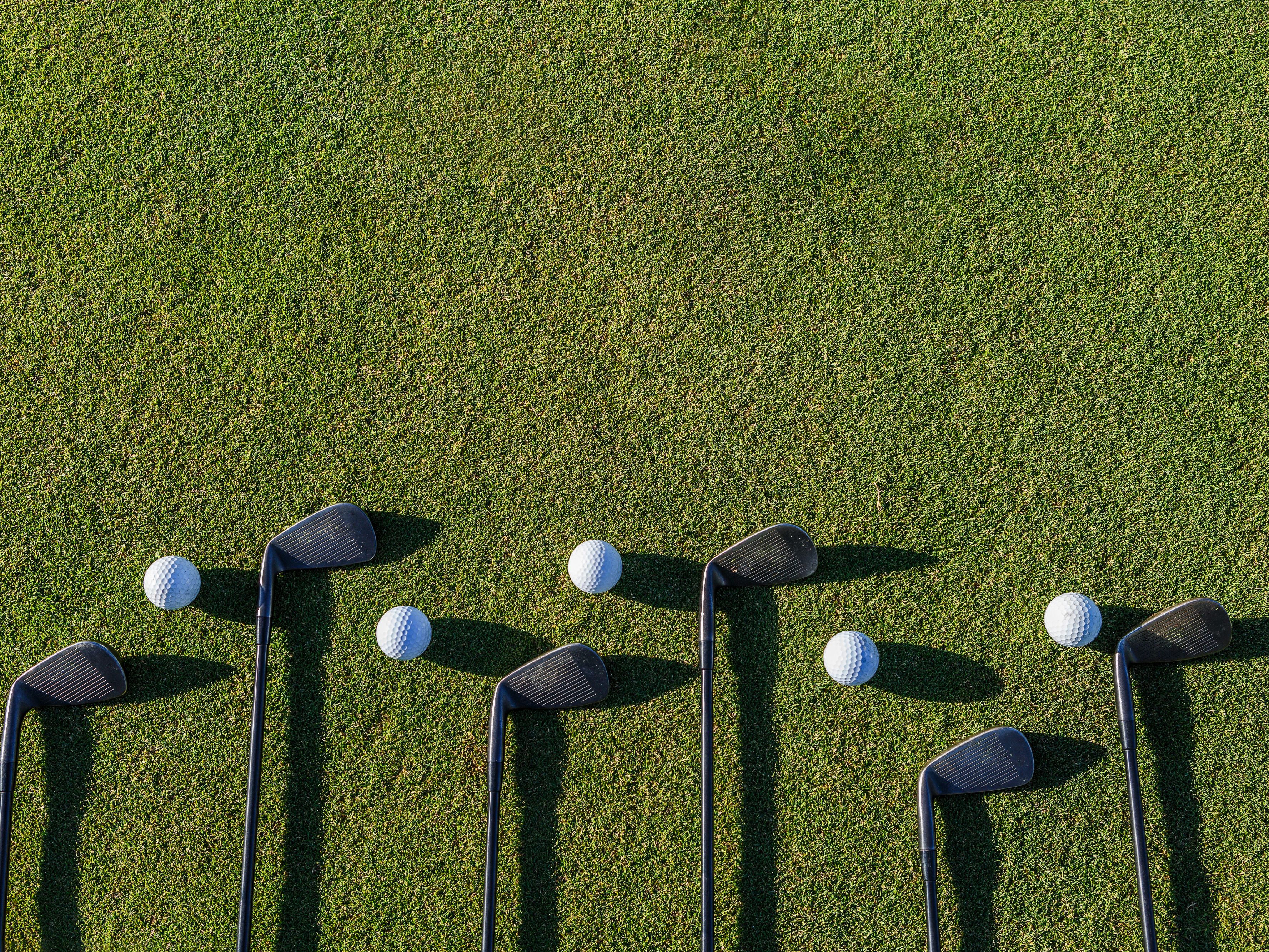 Golf clubs on green grass.