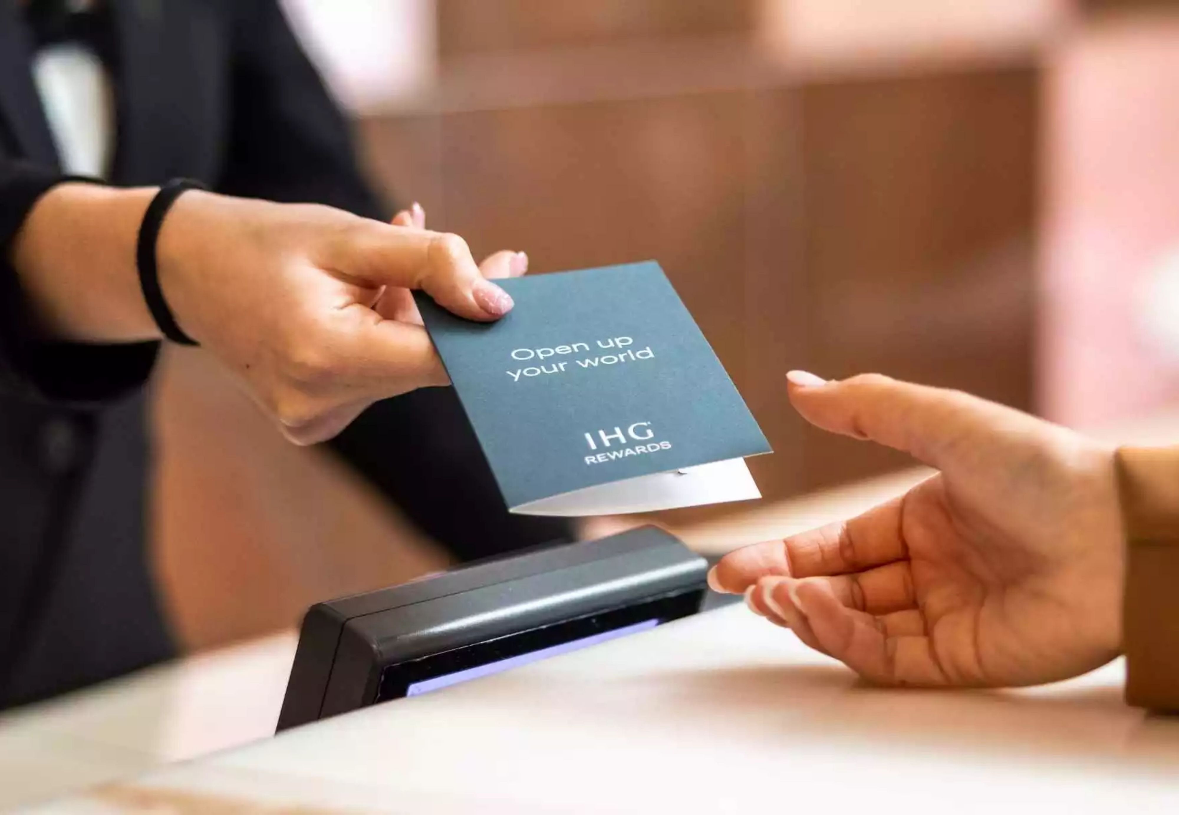 hotel employee handing hotel key card to guest