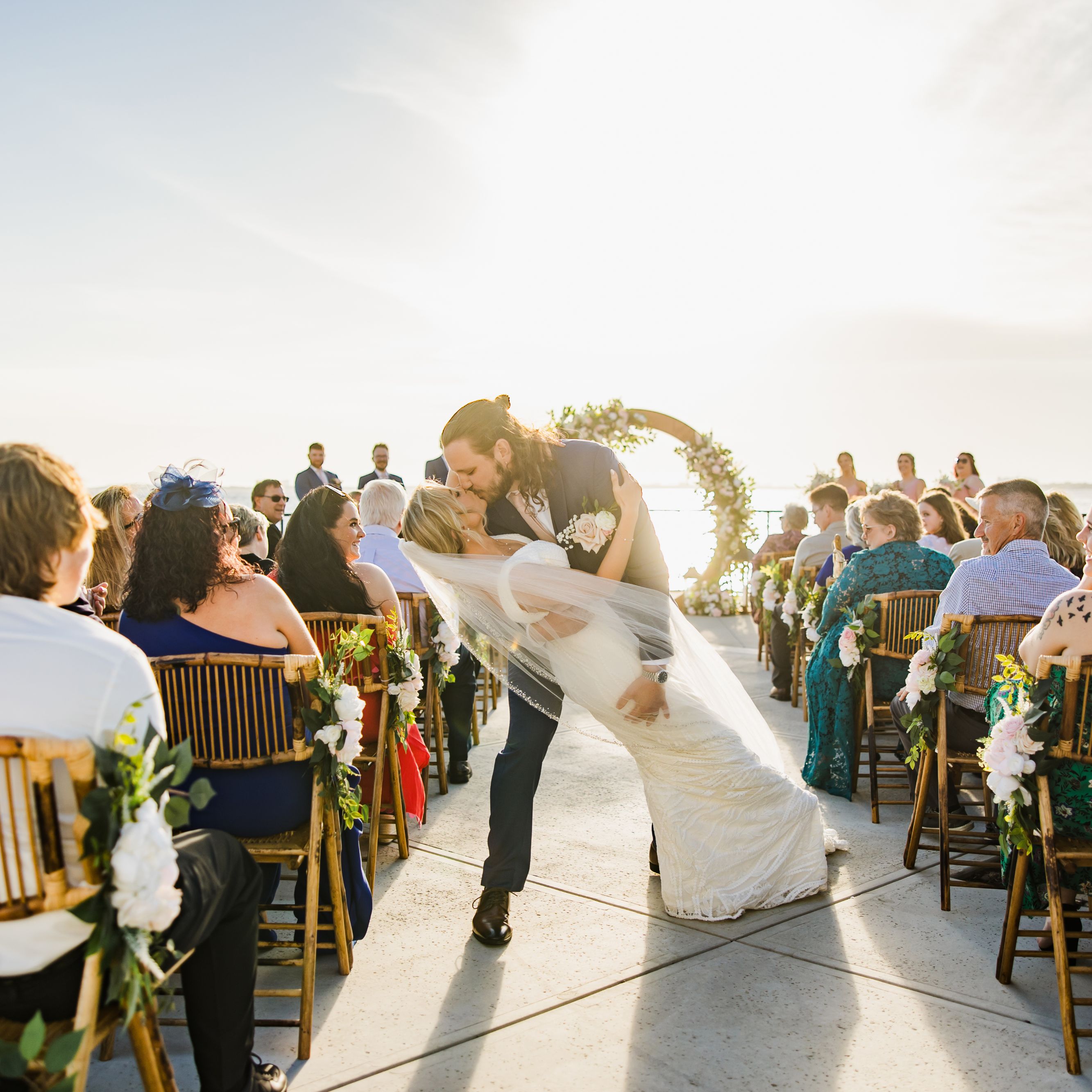 bride and groom kissing in wedding aisle