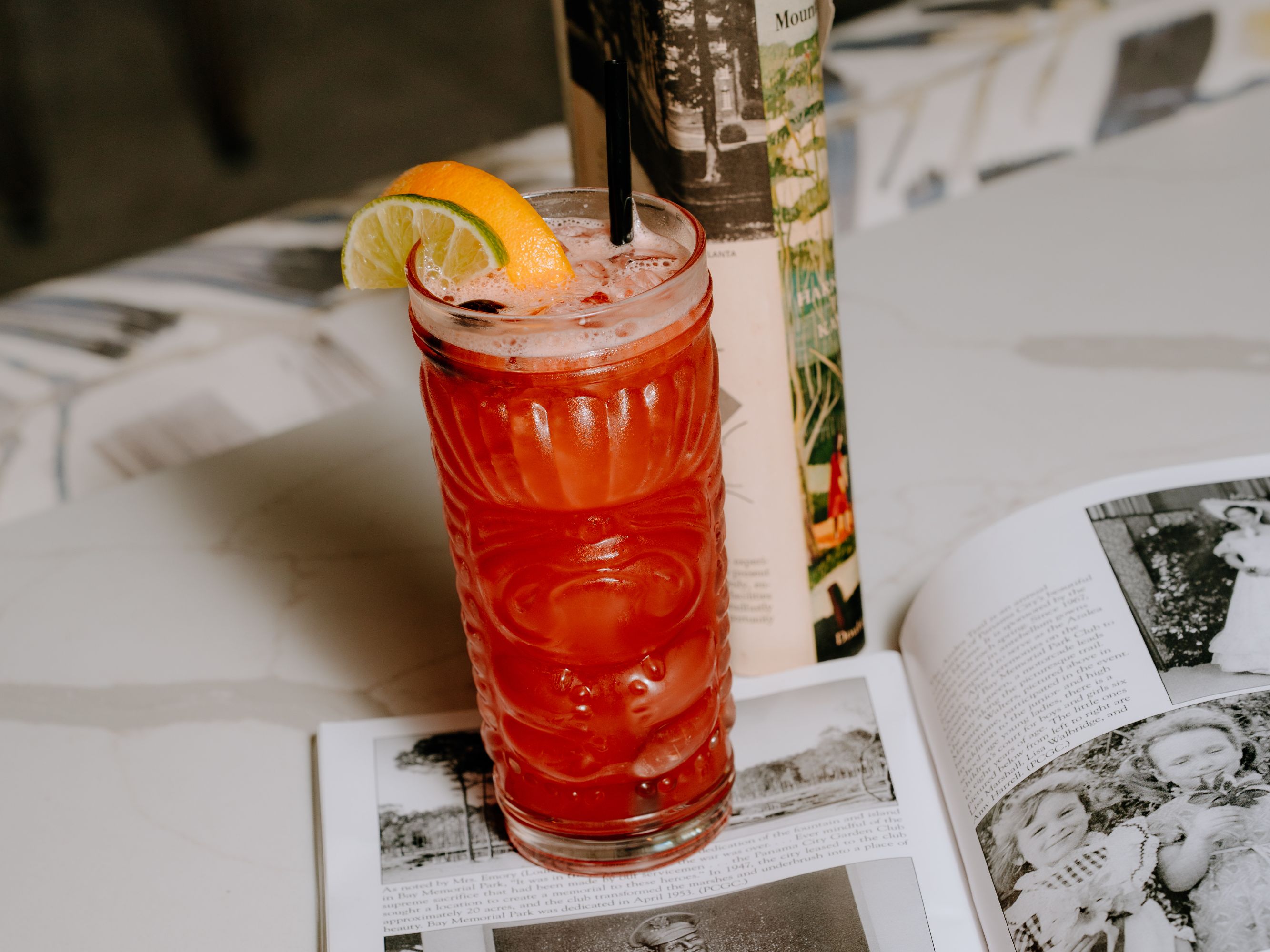 Cocktail with fruit garnish styled with a book.
