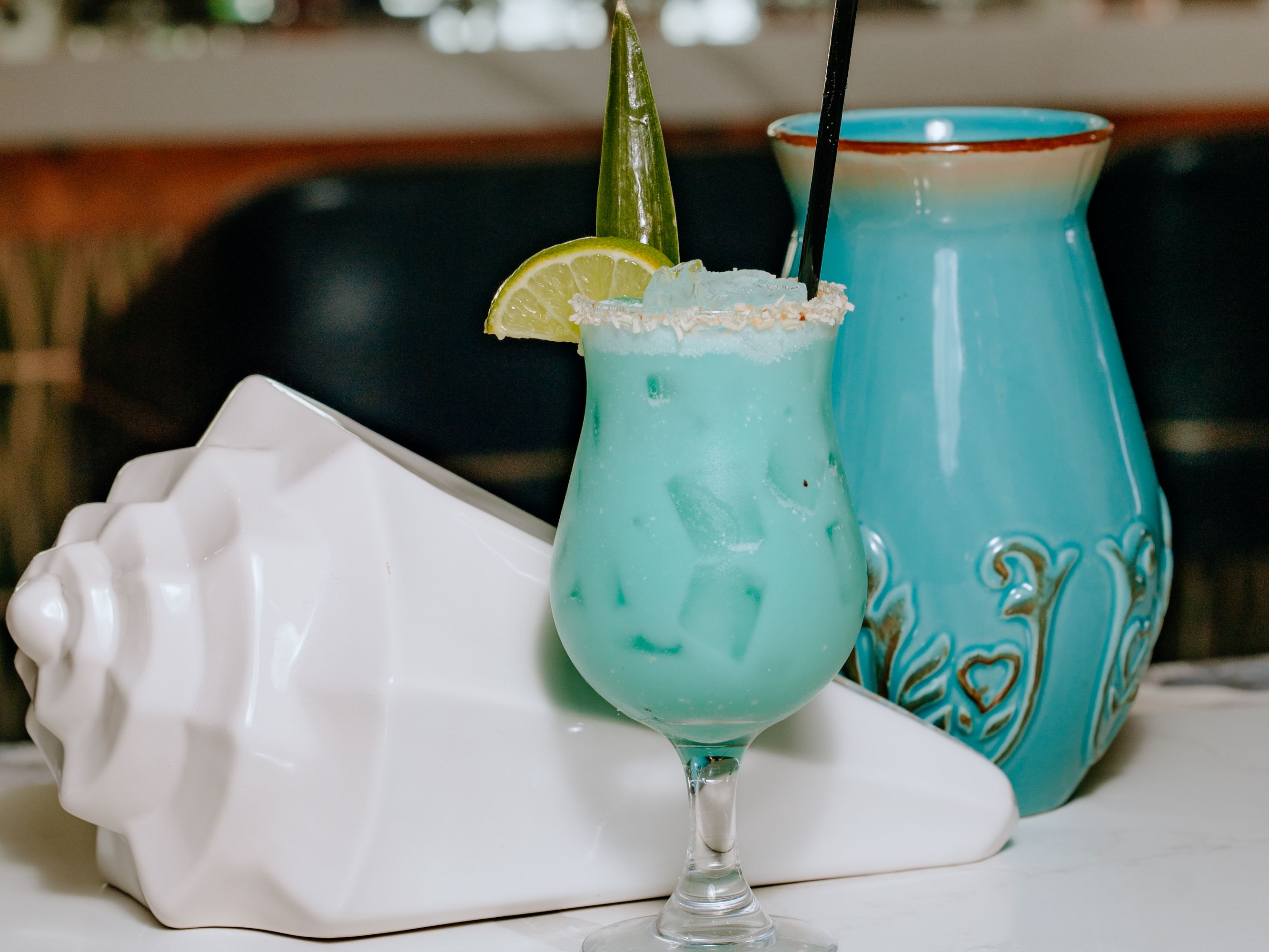 Blue cocktail with lime and sugar garnish.