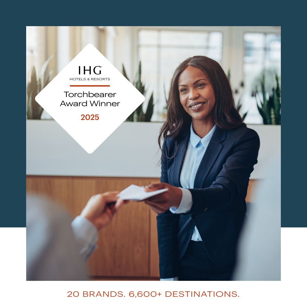 Woman checking a guest into a hotel. Text that reads: IHG Hotels & Resorts Torchbearer Award Winner 2025. 20 Brands, 6,500 Destinations.