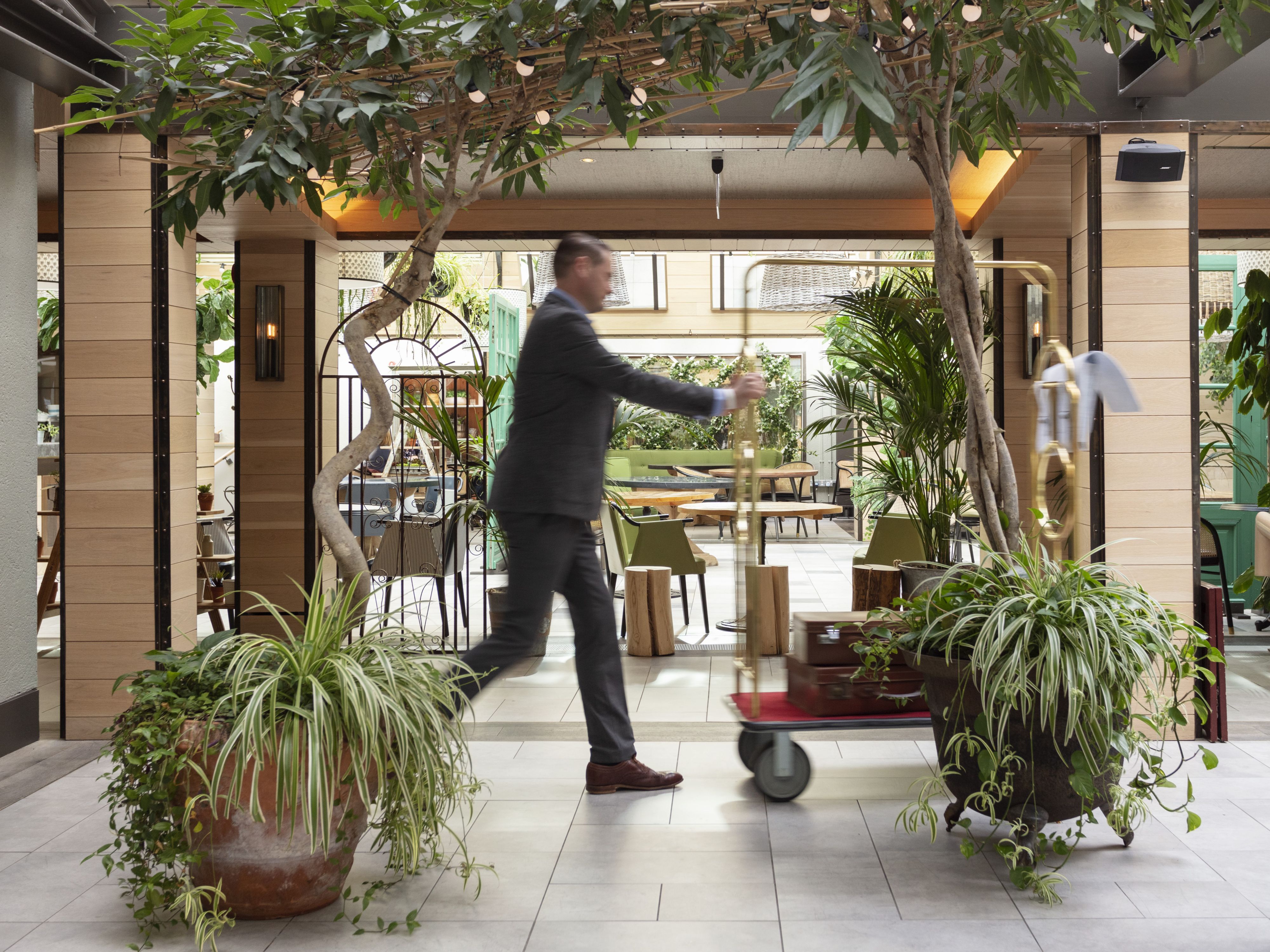 Man pushing a luggage cart through the lobby