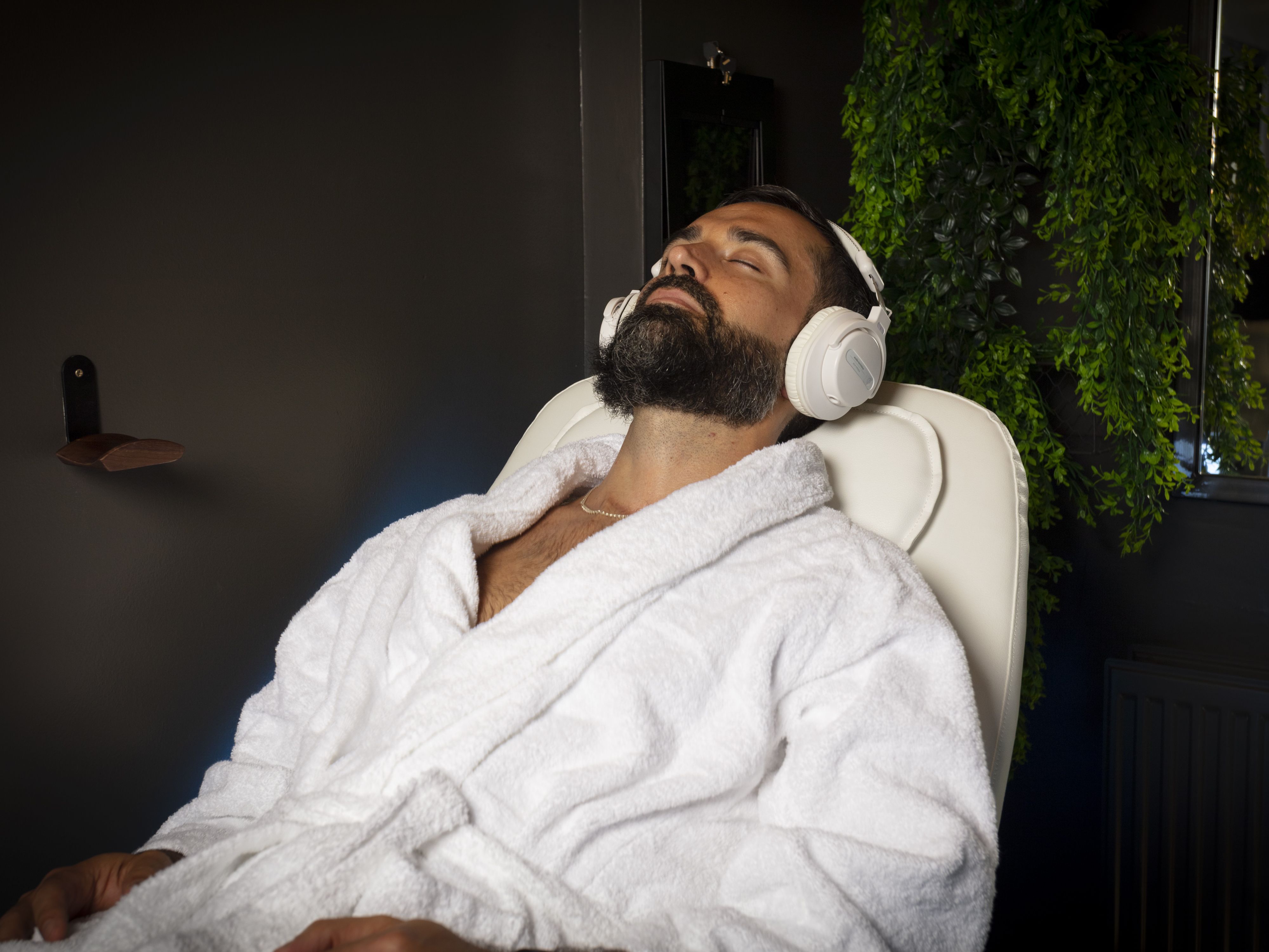 Robed man reclining with headphones