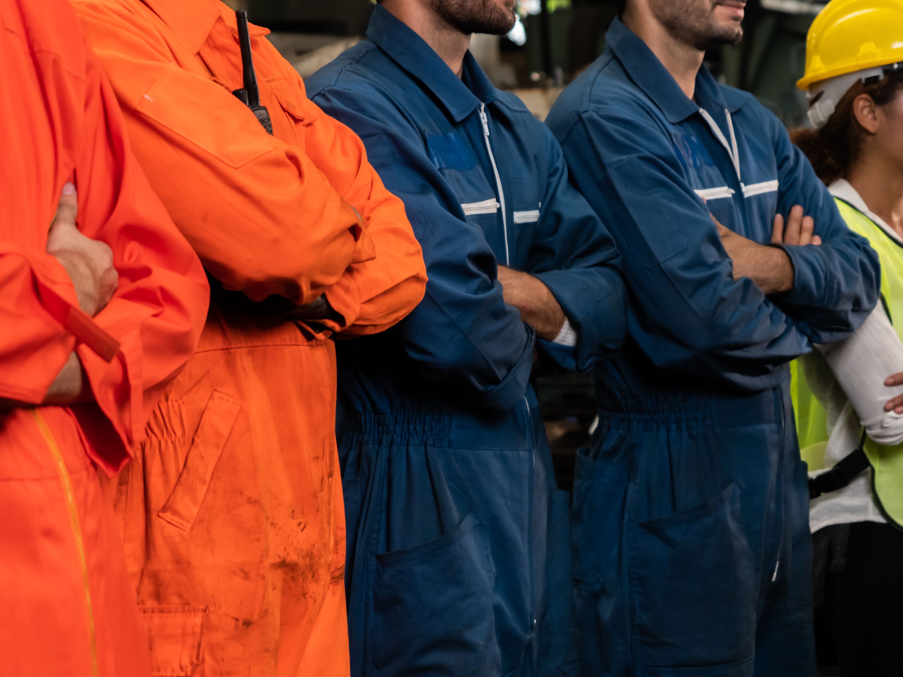 Workers standing in line in jumpsuits.