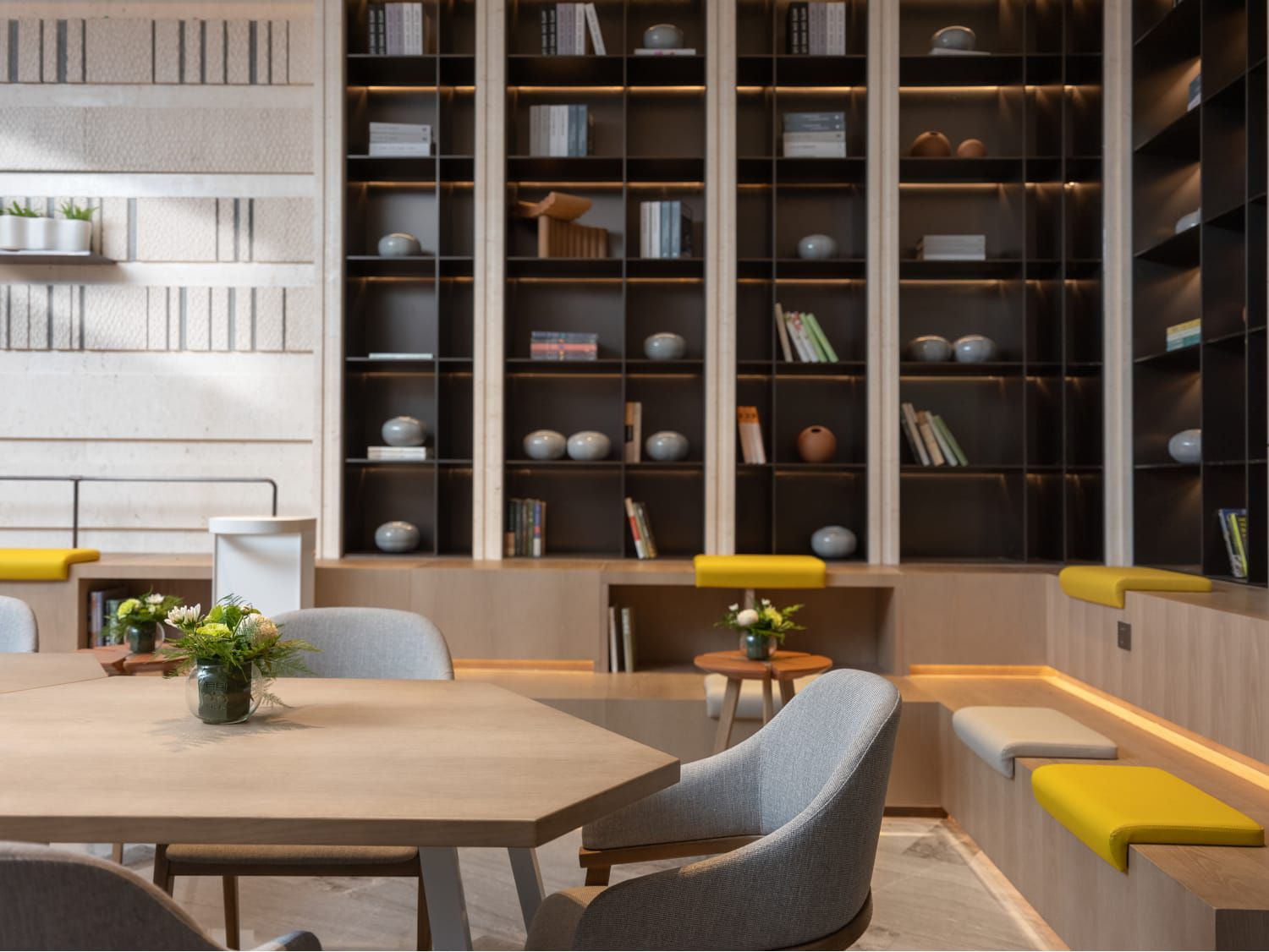 A modern meeting room with tall bookshelves lining the walls and flexible seating options.