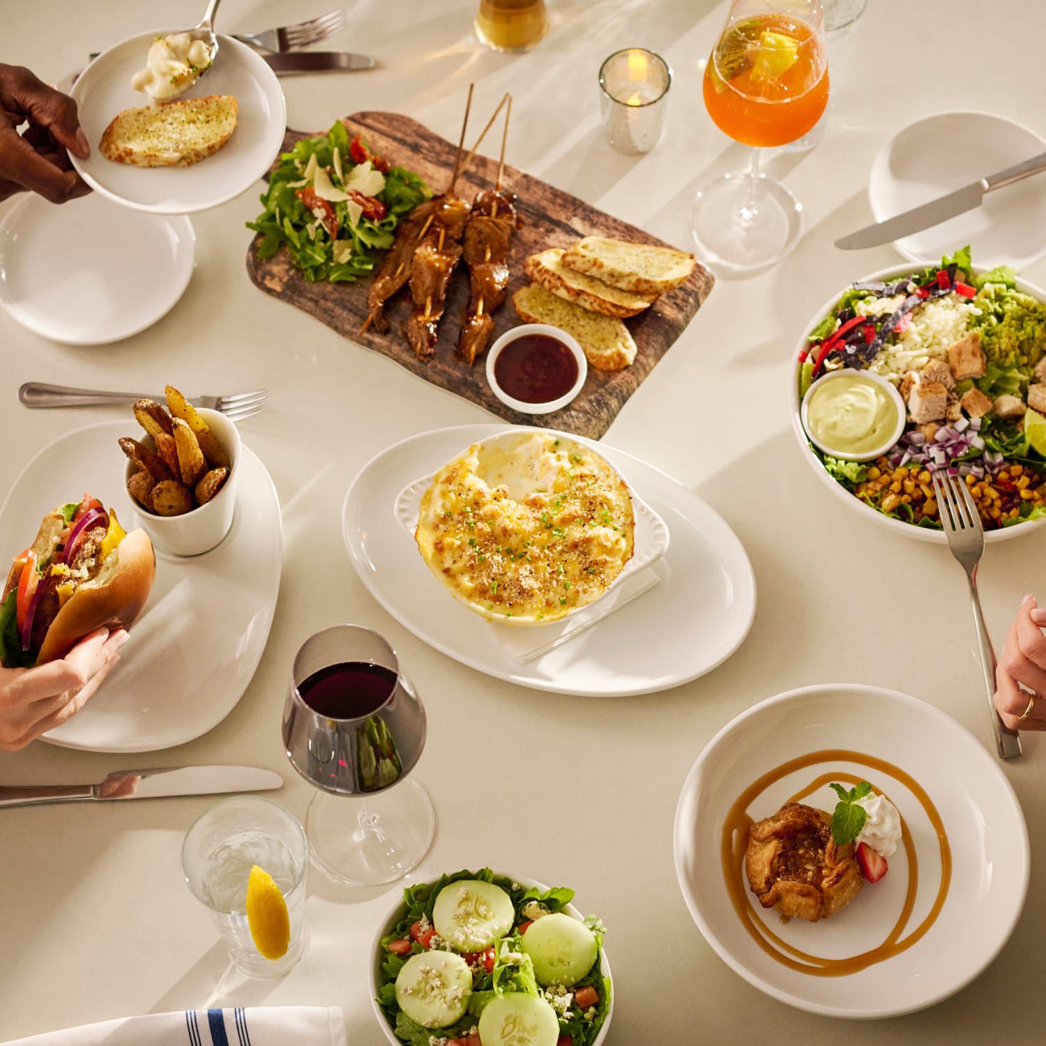 A table filled with delicious dishes including salad, sandwiches, chicken, and dessert.