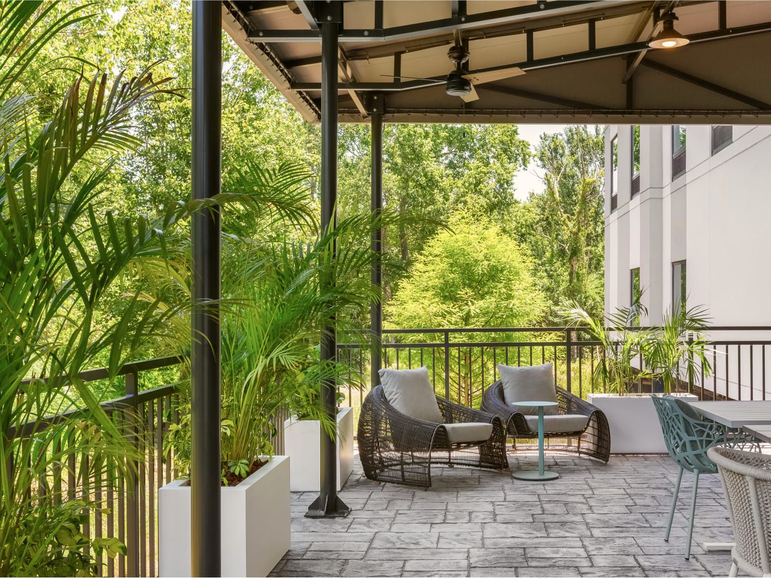 Outdoor seating on a patio surrounded by lush greenery