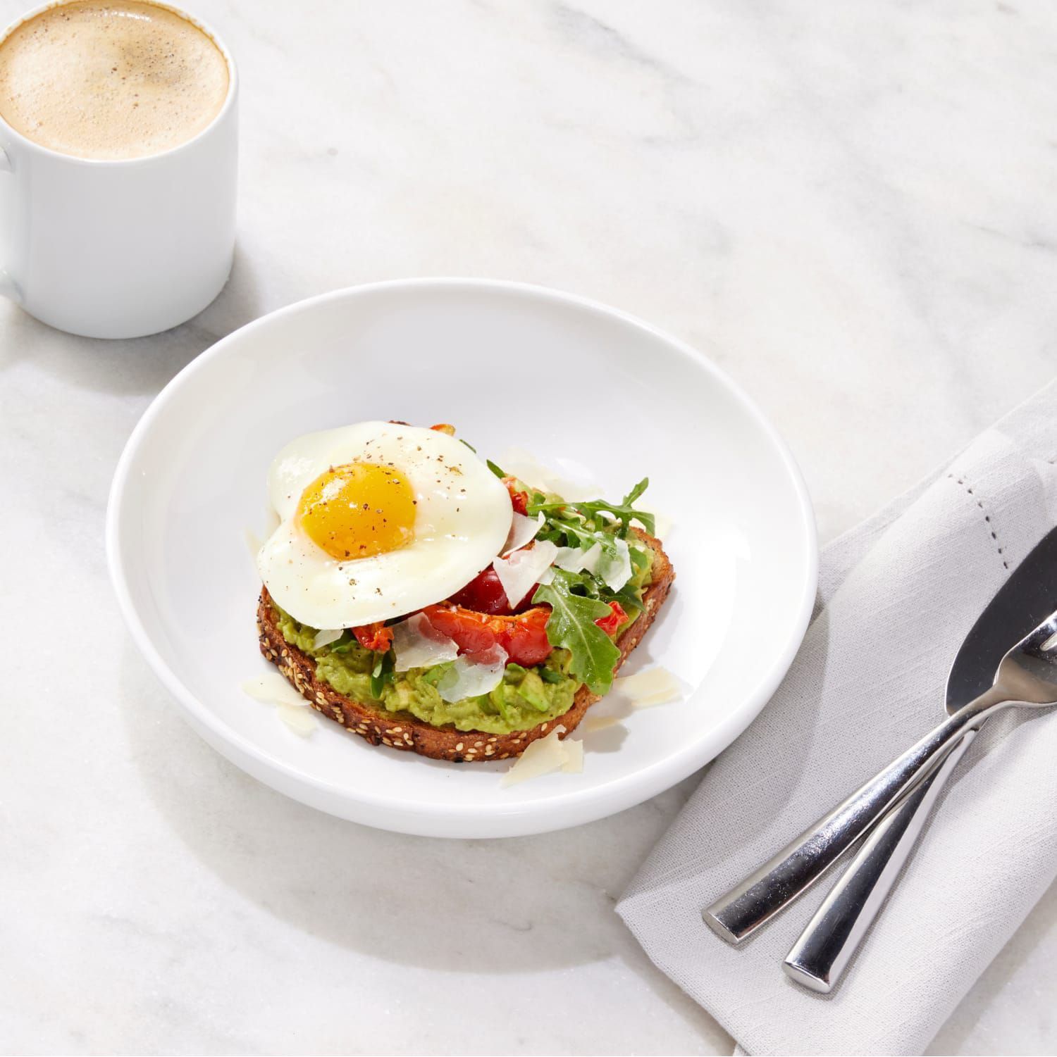 Morning coffee and avocado toast topped with an egg