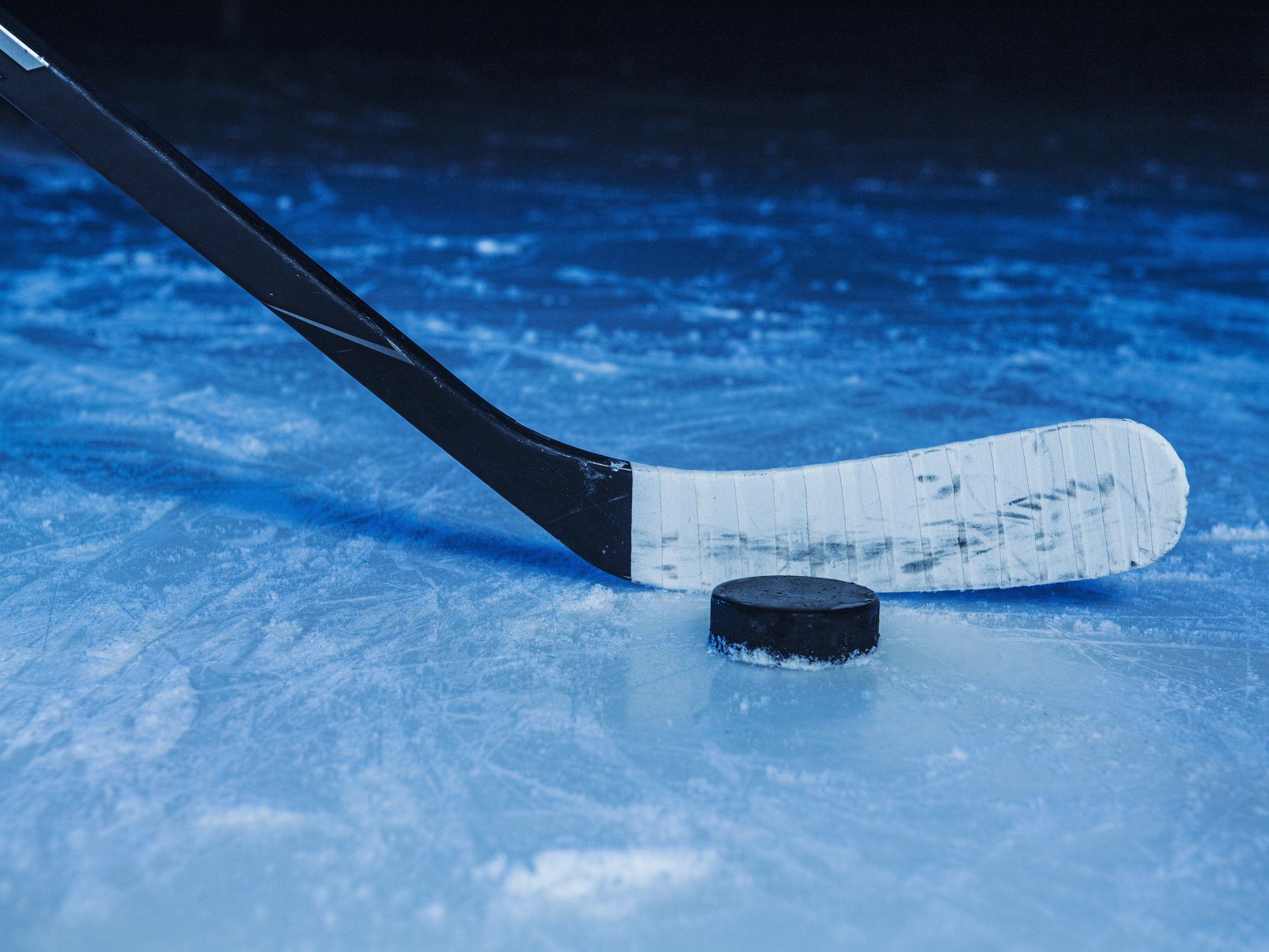 Hockey stick behind a hockey puck