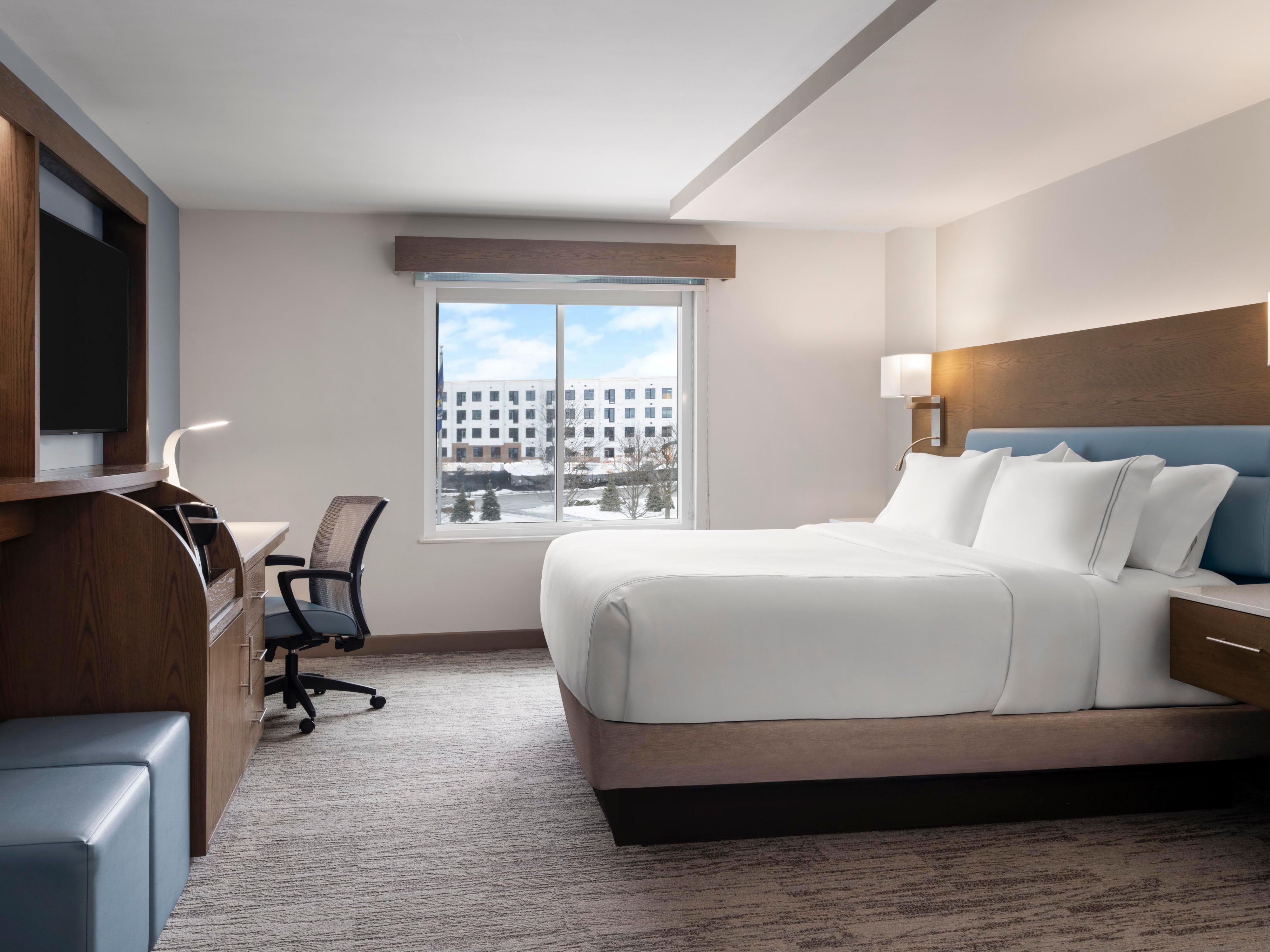 Bright king room with media center and ergonomic workstation.