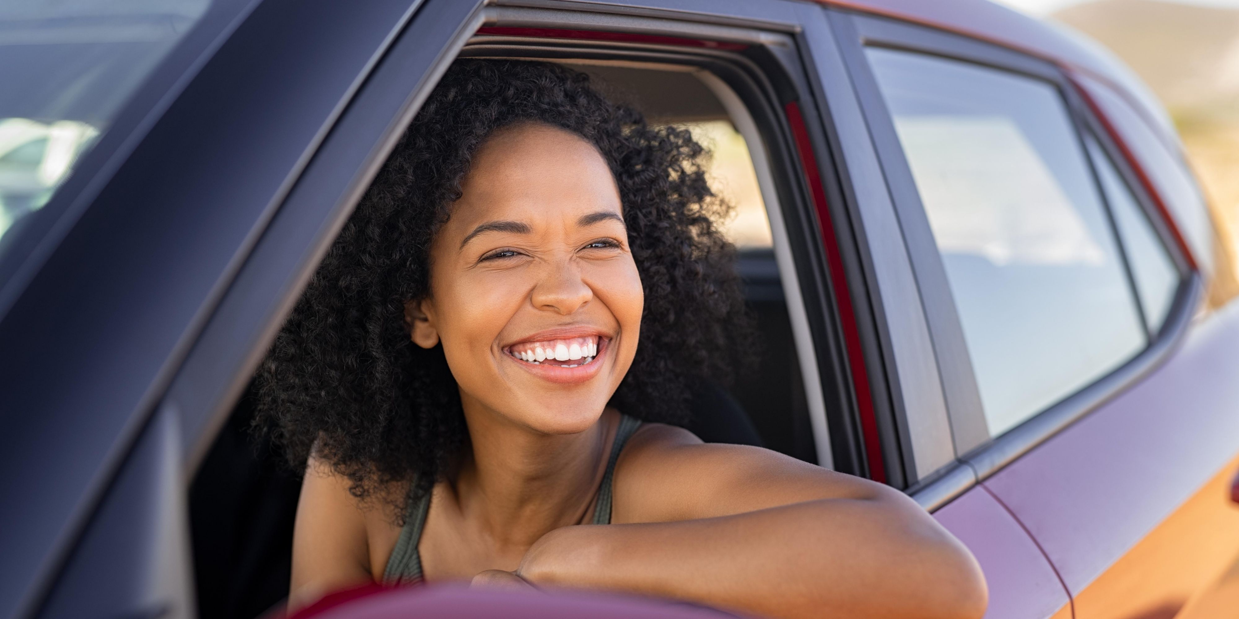 Woman in a car smiling at camera