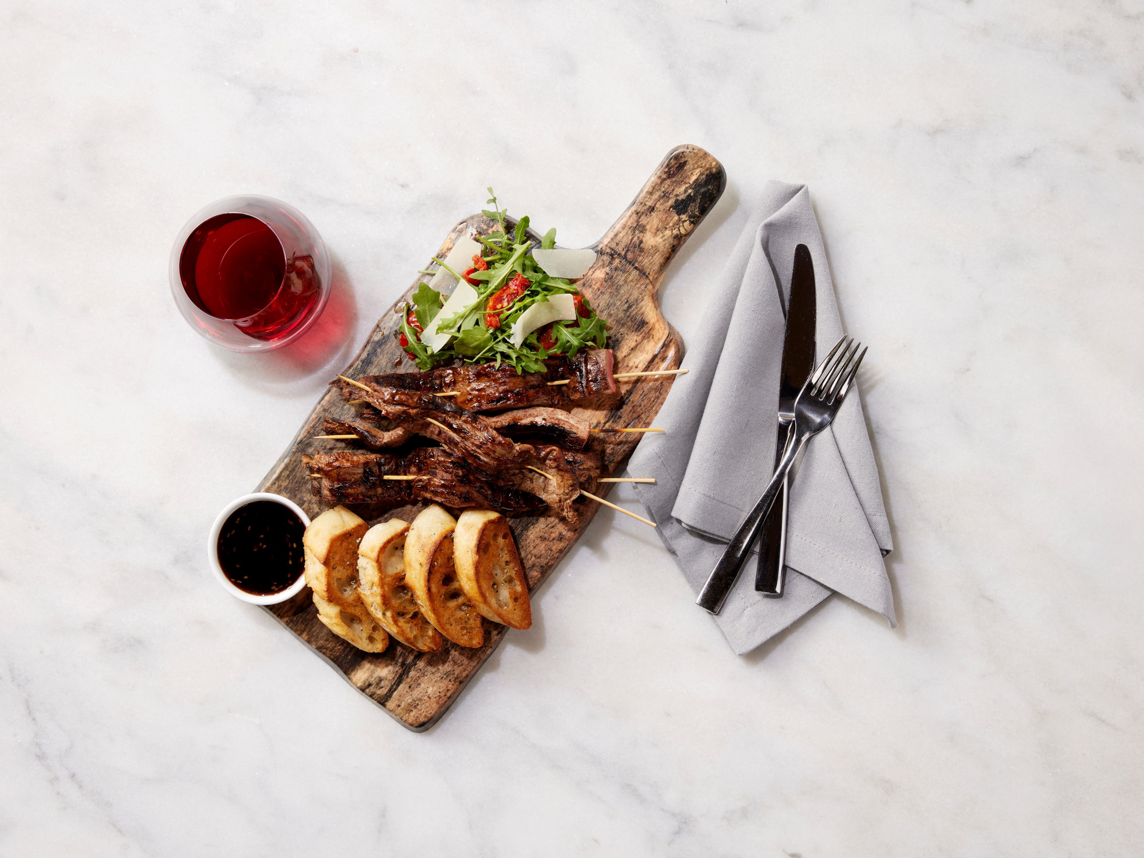 Steak skewers with a salad and crusty bread